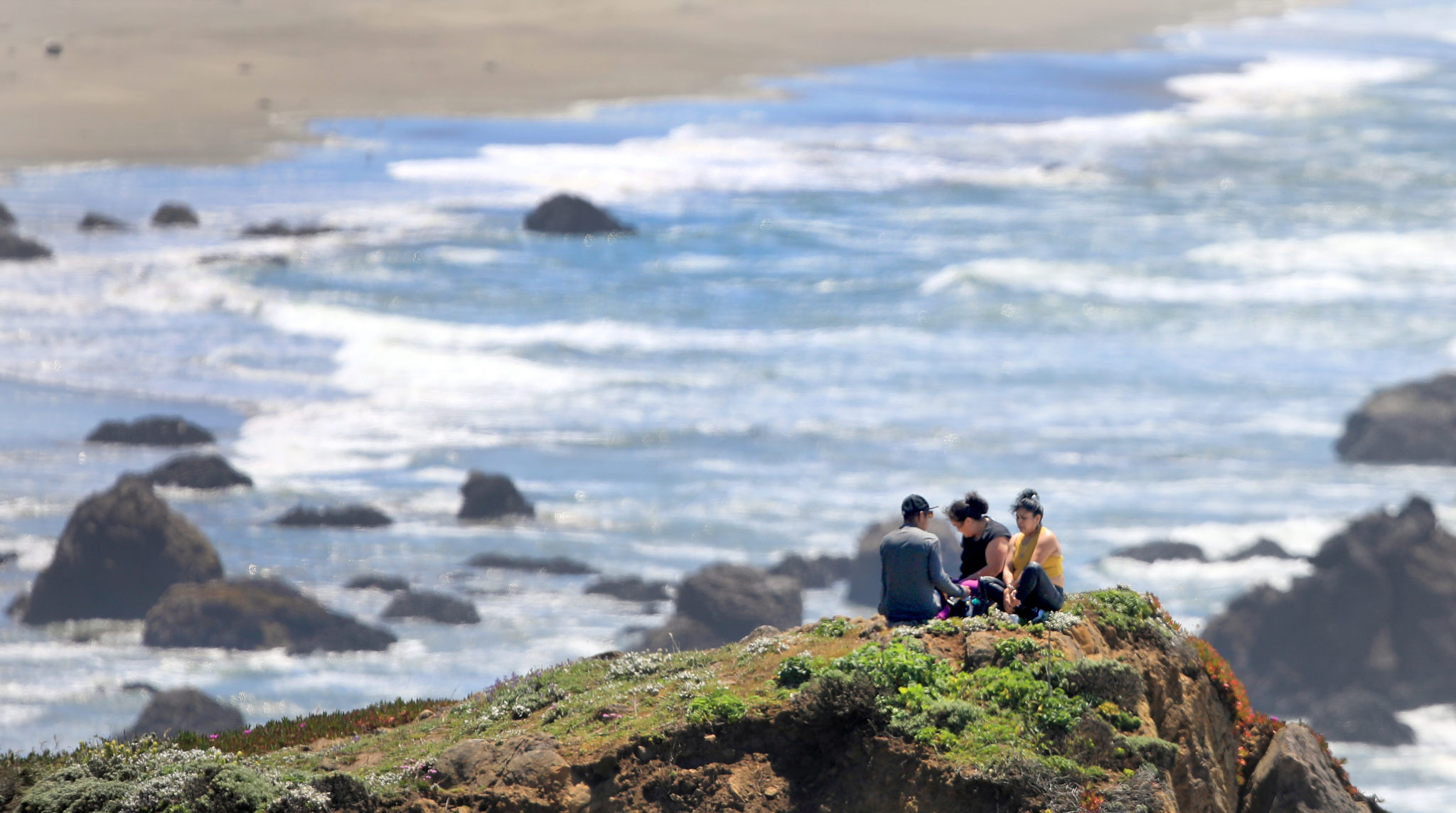 Even though the pullouts are closed along the Sonoma Coast State Beach, a group takes in some vitamin D at Coleman Beach, Tuesday, May 19, 2020. Minutes later a State Parks ranger asked them to leave, which the did.(Kent Porter / The Press Democrat) 2020