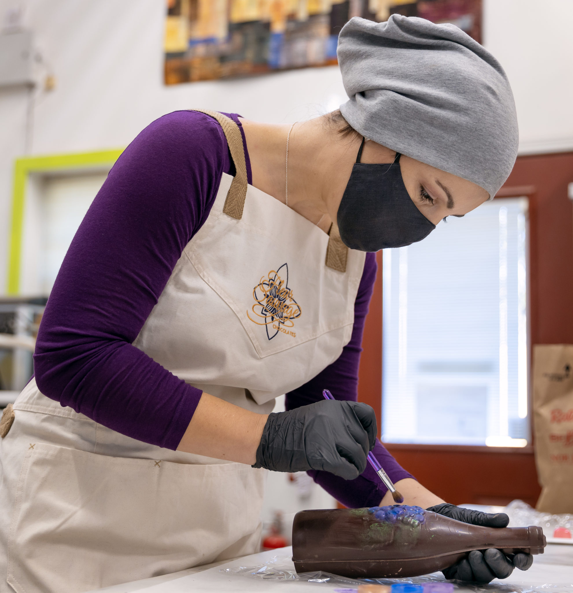 Tara Nieto paints a chocolate wine bottle that will be filled with bonbons. When she is not working alongside her husband, she is a fire engineer on the front lines. (Chris Hardy / Sonoma Magazine)