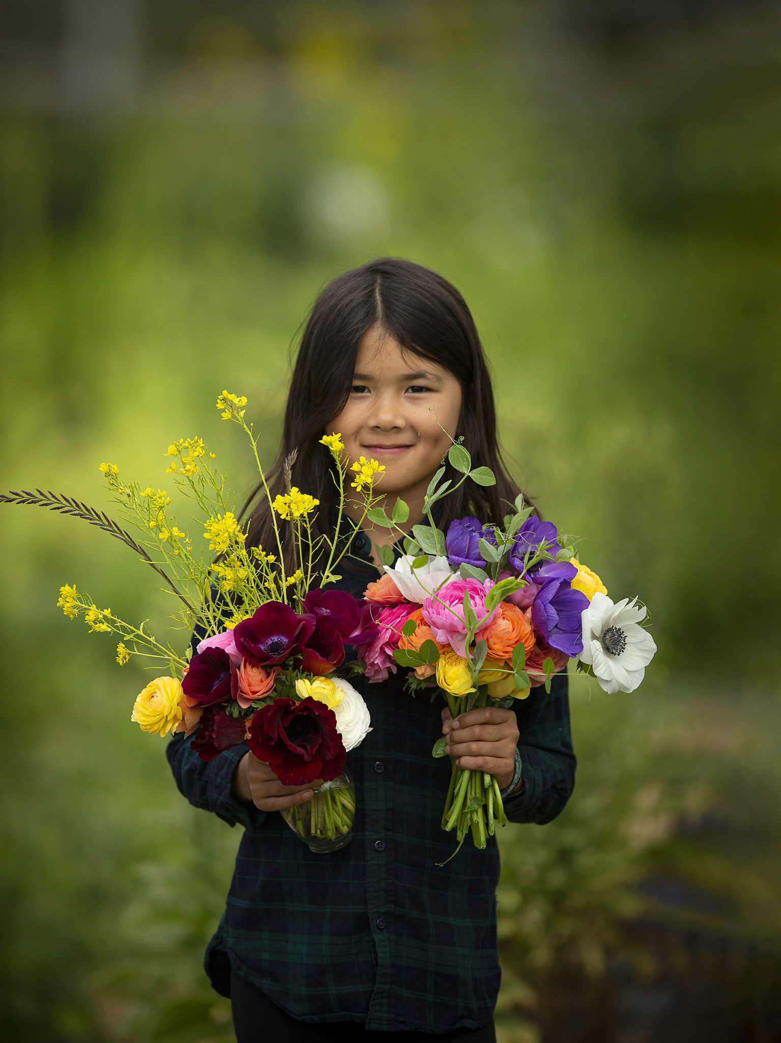 A girl proudly shows off the bouquets she arranged from the flowers at Radical Family Farms in Sebastopol. (John Burgess/The Press Democrat)
