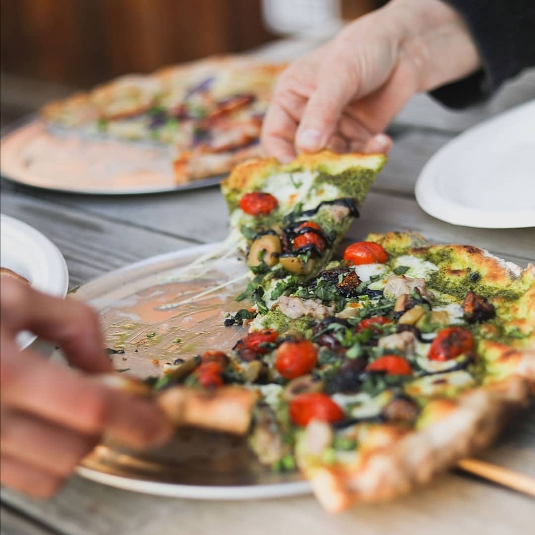 The Kratos with pesto sauce, mozzarella, fire-blistered cherry tomatoes, spicy Italian sausage, olives and figs, finished with fresh basil and balsamic glaze at Zimi Pizza at The Block in Petaluma. (Courtesy of Zimi Pizza)