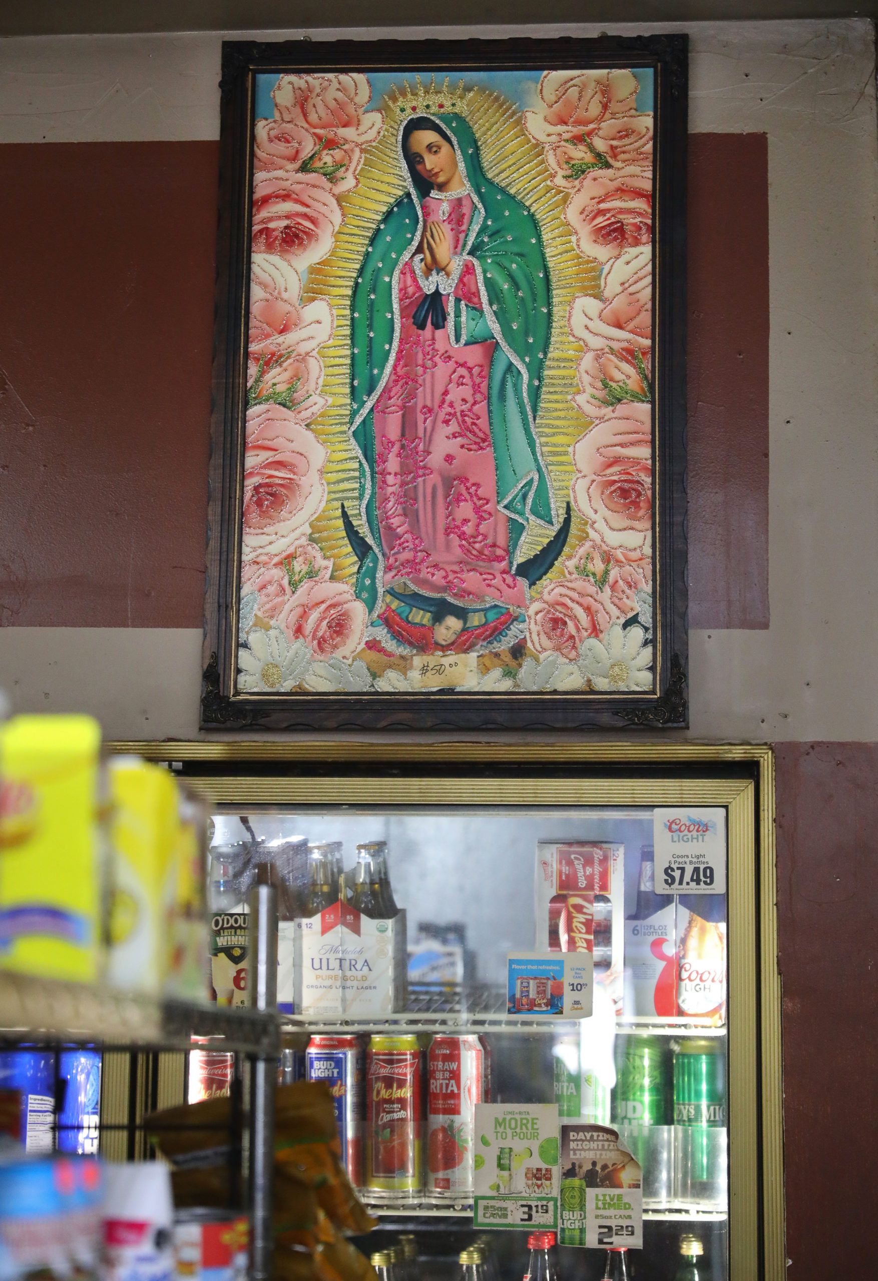 A picture of the Virgin of Guadalupe hangs on a back wall of the El Brinquito Market in Boyes Hot Springs. (Christopher Chung/ The Press Democrat)