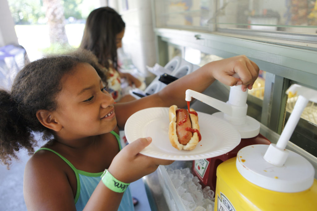 Madera Travis, 5, fixes her hot dog during lunchtime at the snack shop at Morton's Warm Springs in Glen Ellen, California on Thursday, June 30, 2011. (BETH SCHLANKER/ The Press Democrat)