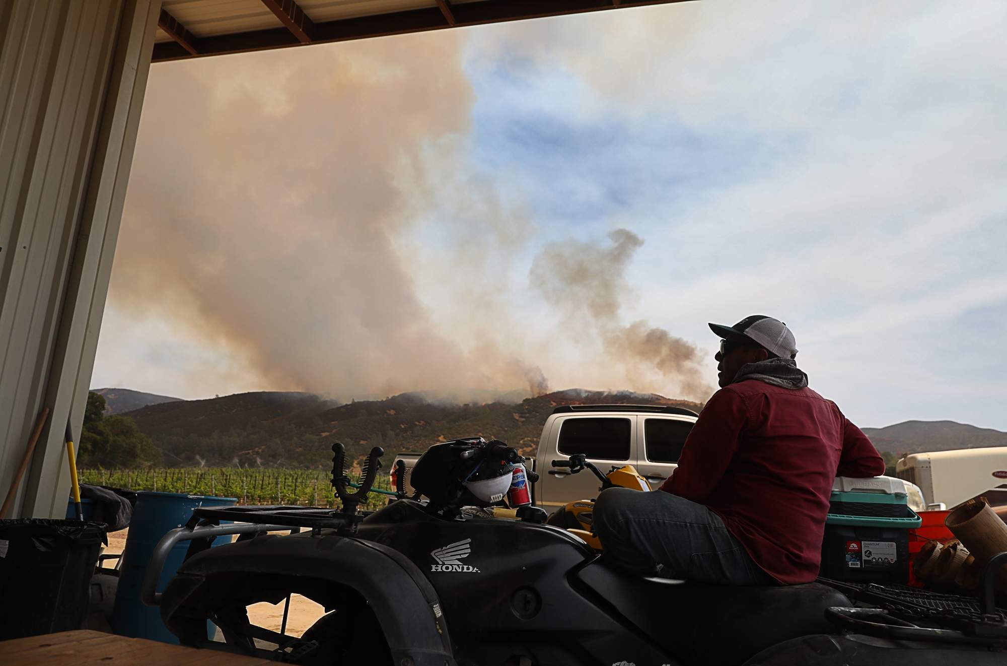 Hilario Reys watches the Pawnee Fire burn from Cache Creek Vineyards, in the Spring Valley community east of Clearlake Oaks on Tuesday, June 26, 2018. (Christopher Chung/ The Press Democrat)