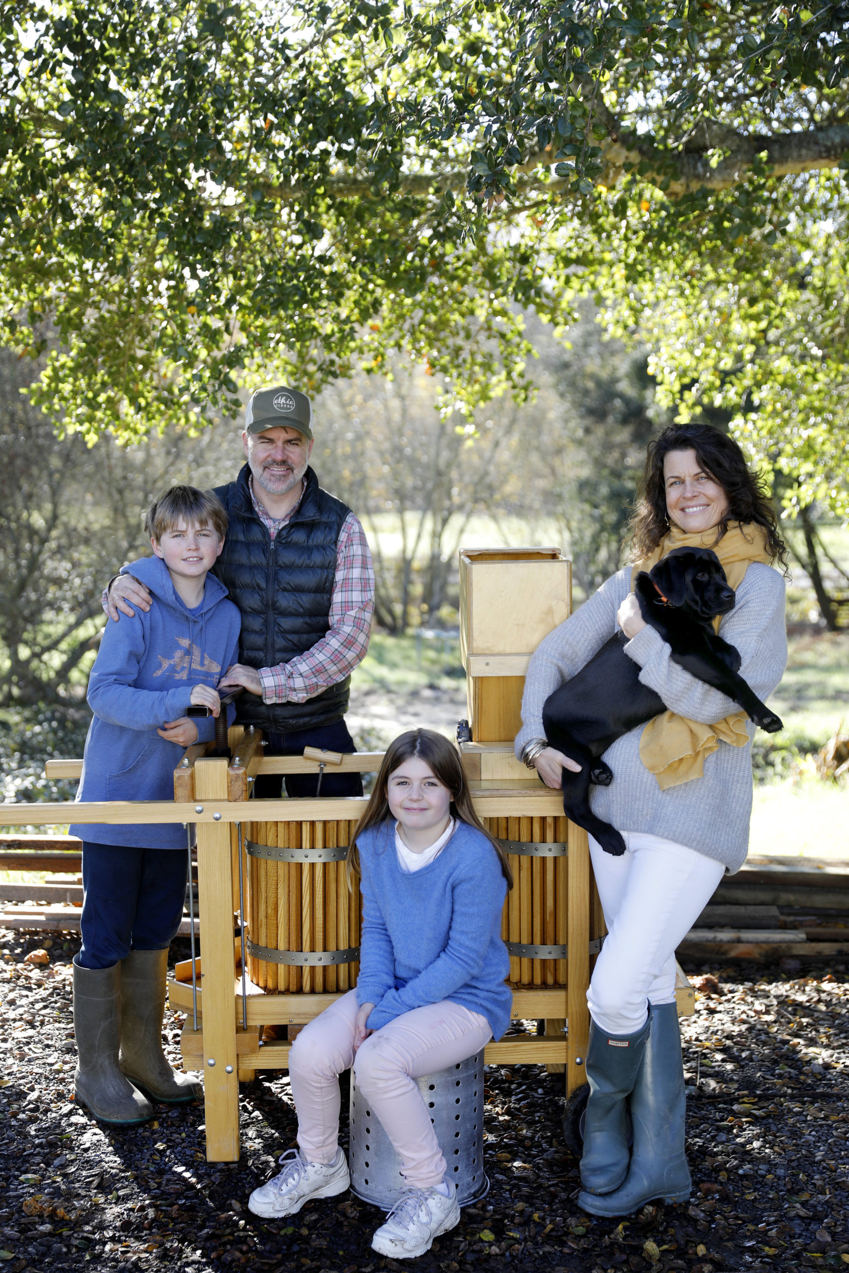 Ethic Ciders owners Ned and Michelle Lawton, their son Kielson, 12, daughter Remi, 9, and puppy, Luna, stand next to an apple press at their apple farm on Wednesday, December 26, 2018 in Sebastopol, California . (BETH SCHLANKER/The Press Democrat)