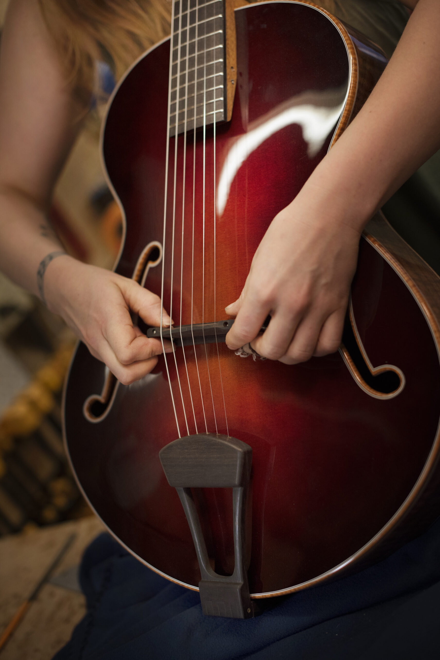 Guitar maker Maegen Wells, 32, adjusting the bridge of one of her small body archtop acoustic guitars in her home-based workshop in Forestville, California on June 4, 2020. (Photo: Erik Castro/for Sonoma Magazine)