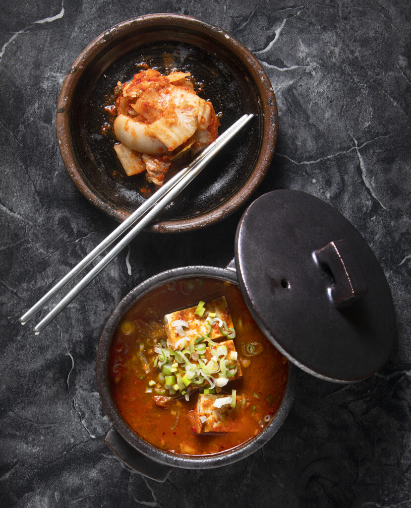 Kimchi Jjigae, bottom, spicy homemade kimchi soup with pork and organic tofu, and a side of kimchi from Soban Korean in Petaluma. (Photo by John Burgess/The Press Democrat)