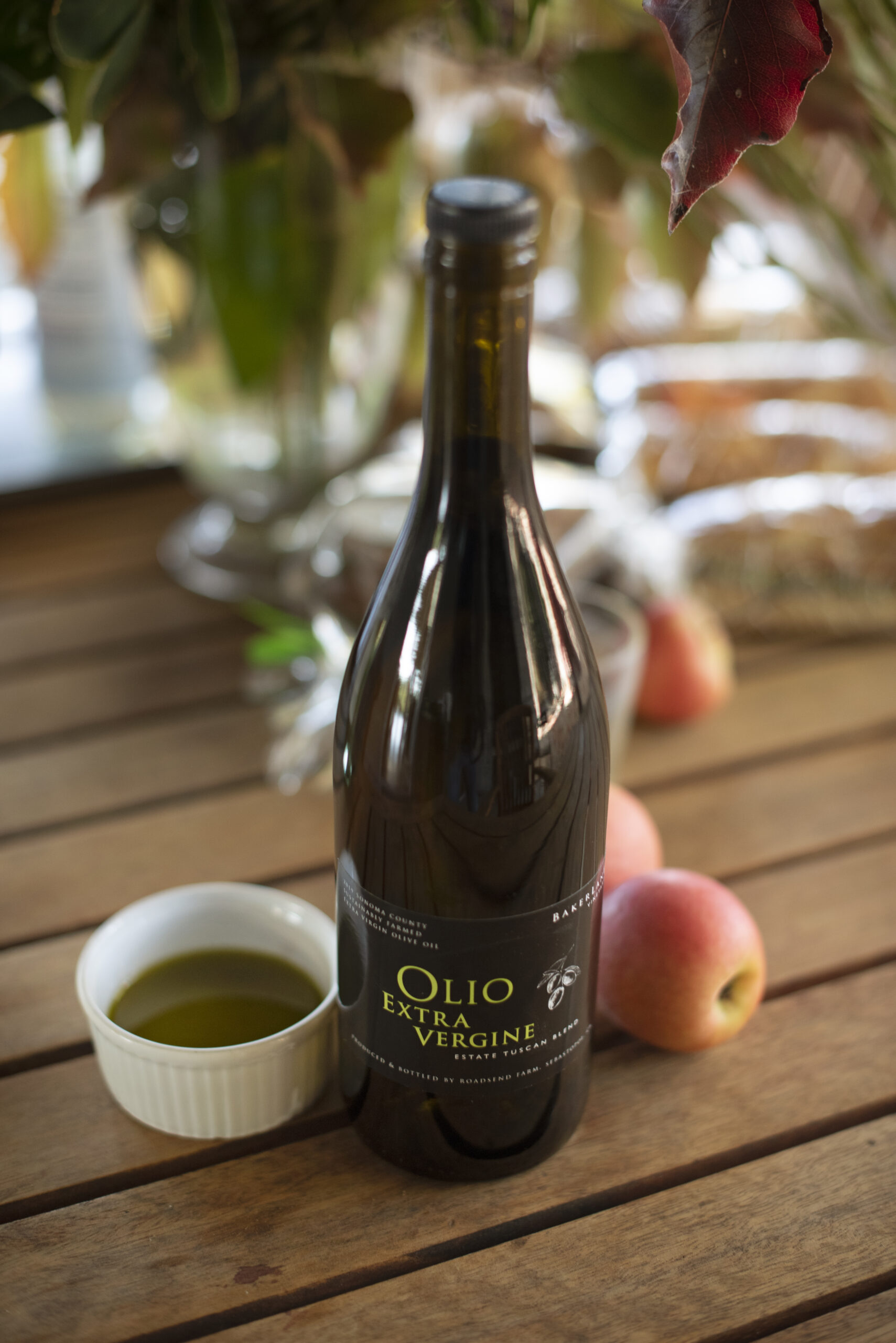 A bottle of Estate Tuscan Blend extra virgin olive oil on the lunch table during olive harvest at Baker Lane Vineyards in Sebastopol. (Erik Castro/for Sonoma Magazine)