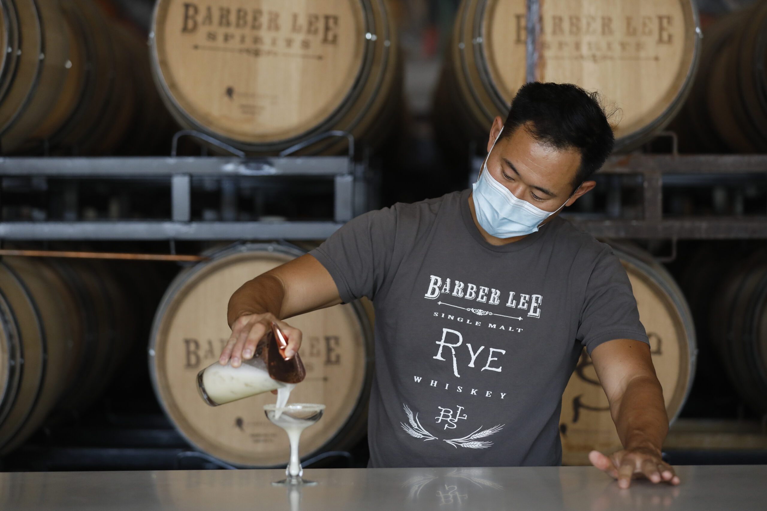 Aaron Lee, co-owner of Barber Lee Spirits, pours a Sicilian Sting, a mix of grappa, honey, lemon juice, egg white, with a chamomile sugar rim, in Petaluma, Calif., on Thursday, December 2, 2021.(Beth Schlanker/The Press Democrat)