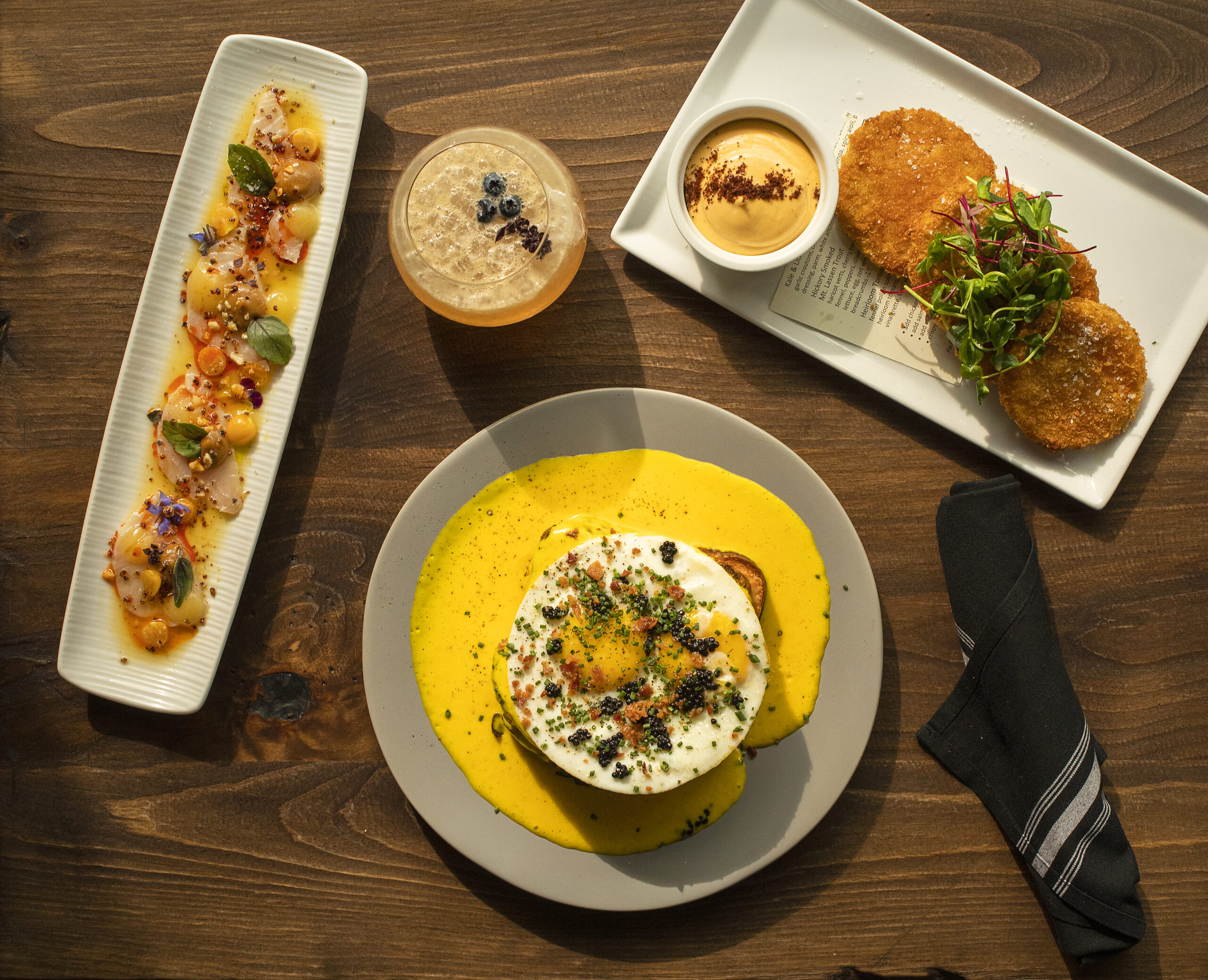 Clockwise from left, Hamachi Crudo, Lavender Liaison cocktail, Fried Green Tomatoes and Lobster Croque Madame from the Blue Ridge Kitchen in Sebastopol's Barlow district. (John Burgess/The Press Democrat)