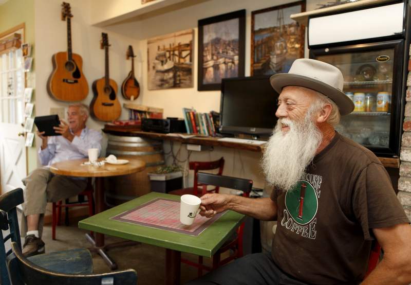 Roadhouse Coffee owner Jim Irving, right, and customer Terry Lanning, left, drink coffee at the shop in Bodega Bay, California on Tuesday, September 13, 2011. (BETH SCHLANKER/ The Press Democrat)