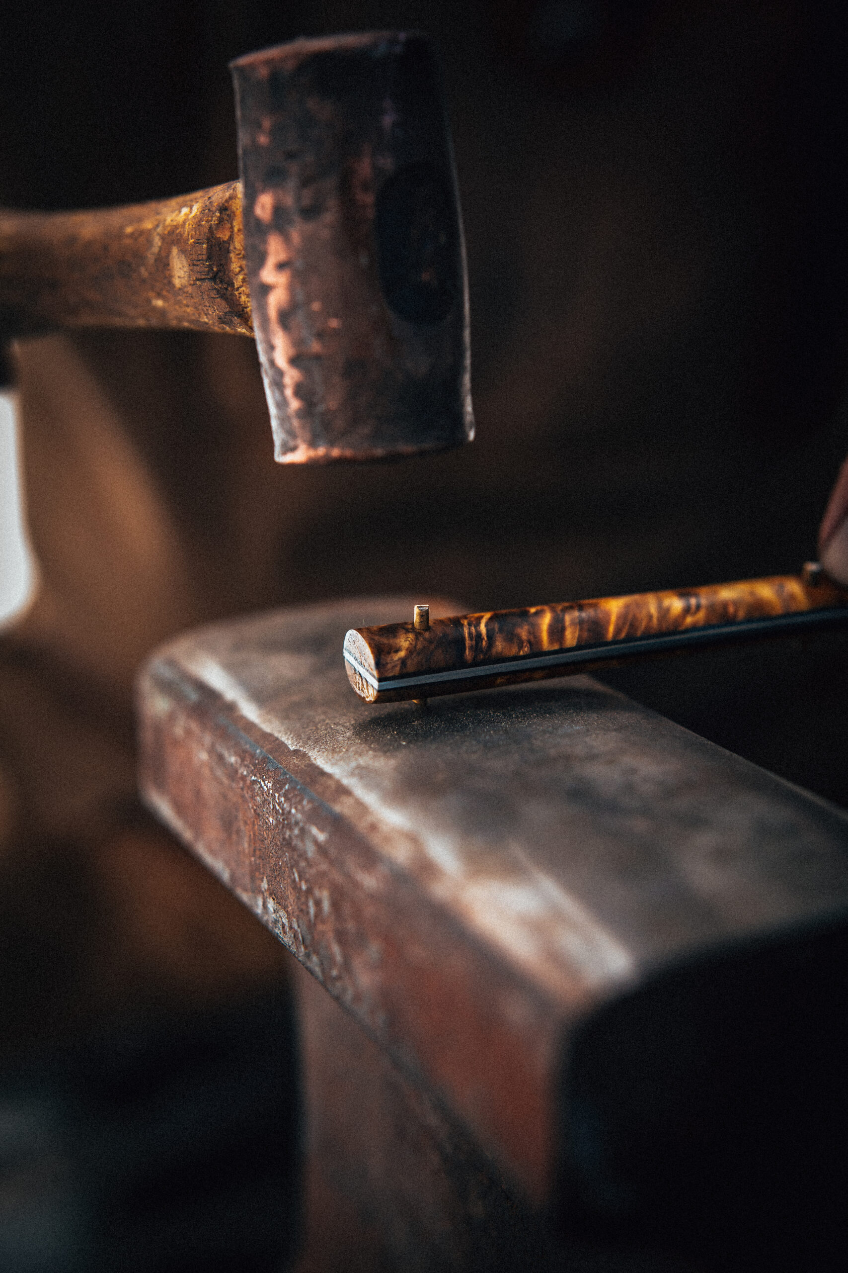 Near the end of production, Benz attaches a polished burlwood handle using an antique mallet. (John Troxell)