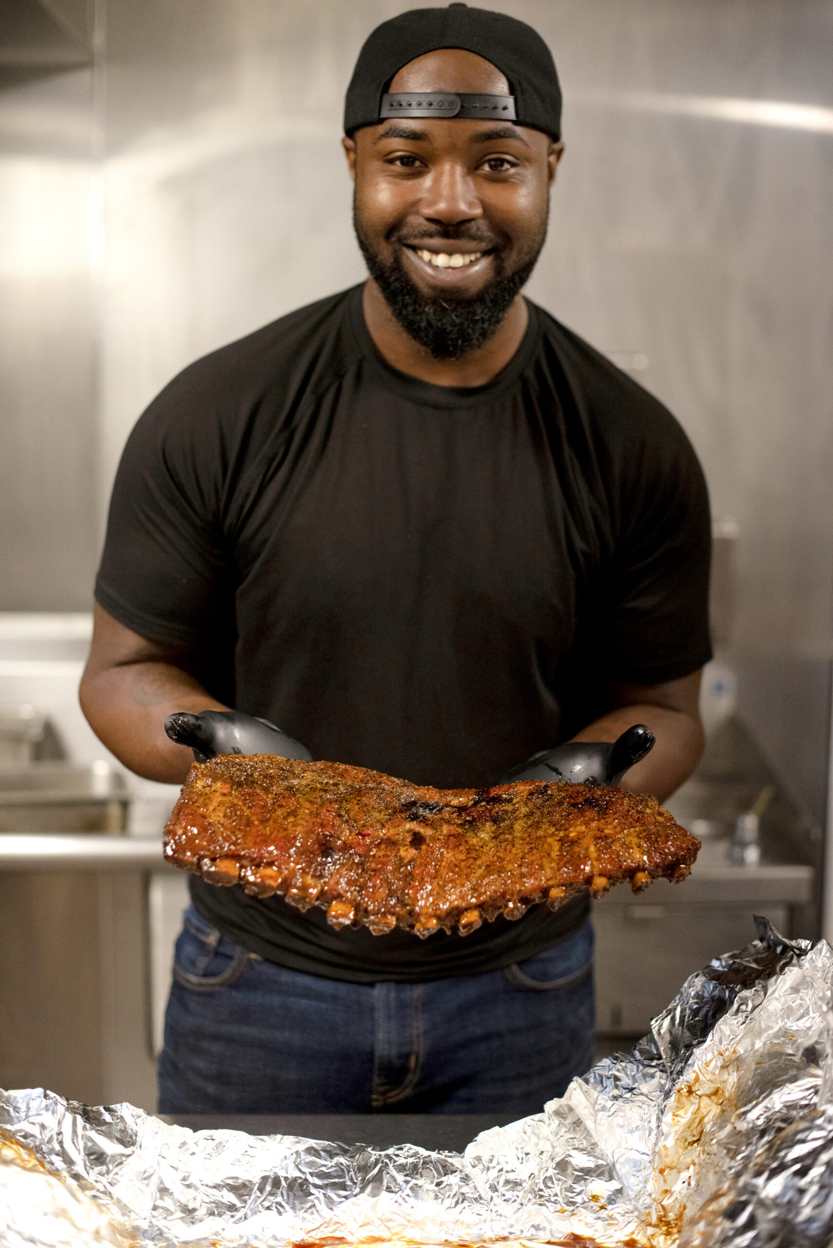 Kris Austin of Austin's Southern Smoke BBQ with some of his ribs ready for serving at Old Possum Brewing Co. in Santa Rosa, California on May 6, 2022. (Photo: Erik Castro/for Sonoma Magazine)