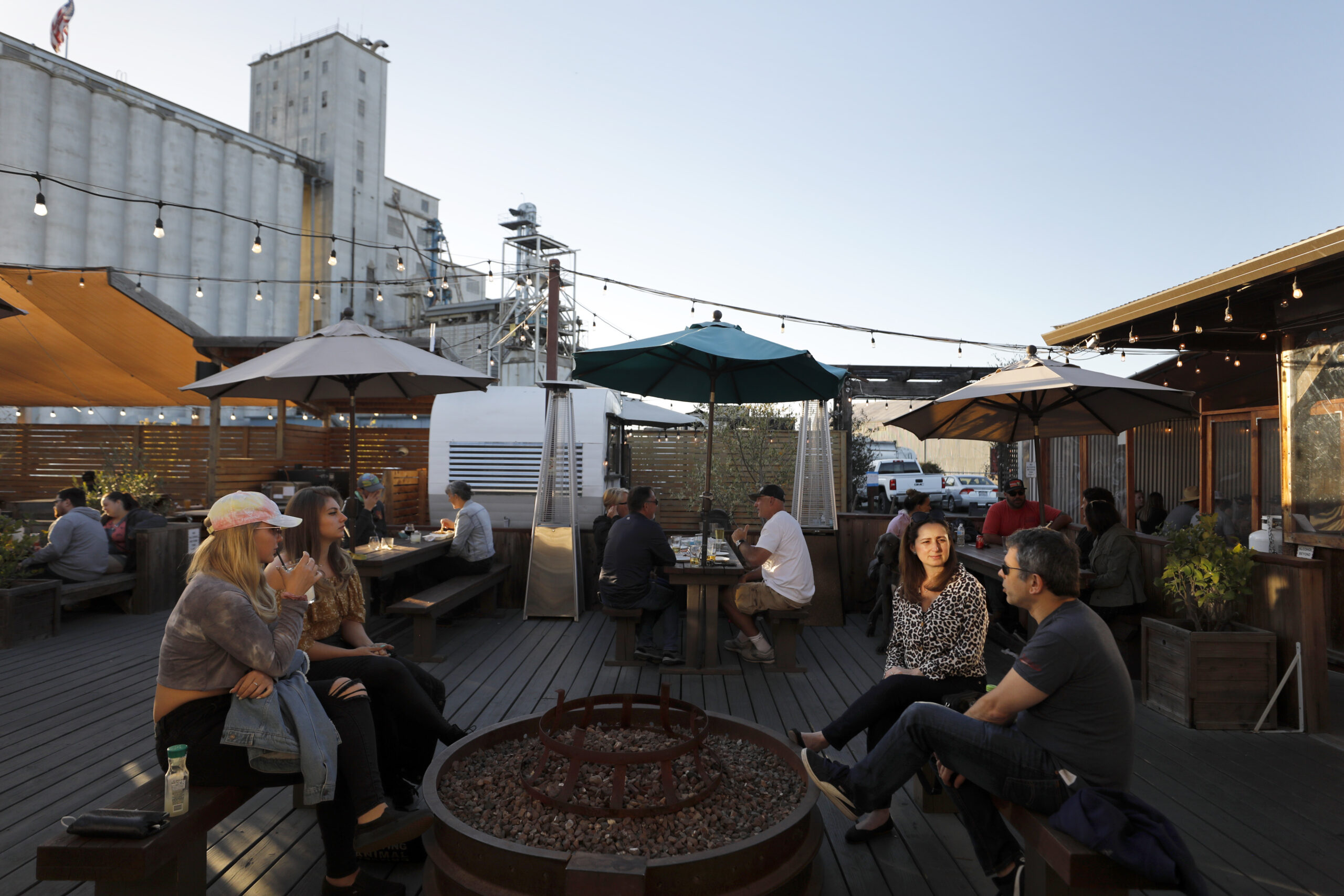 Aine Fitzgerald, from left, Rachael Brackett, Heloisa Maruch and Leonardo Melo have drinks at The Block Petaluma food park in Petaluma, Calif., on Saturday, May 14, 2022.(Beth Schlanker/The Press Democrat)