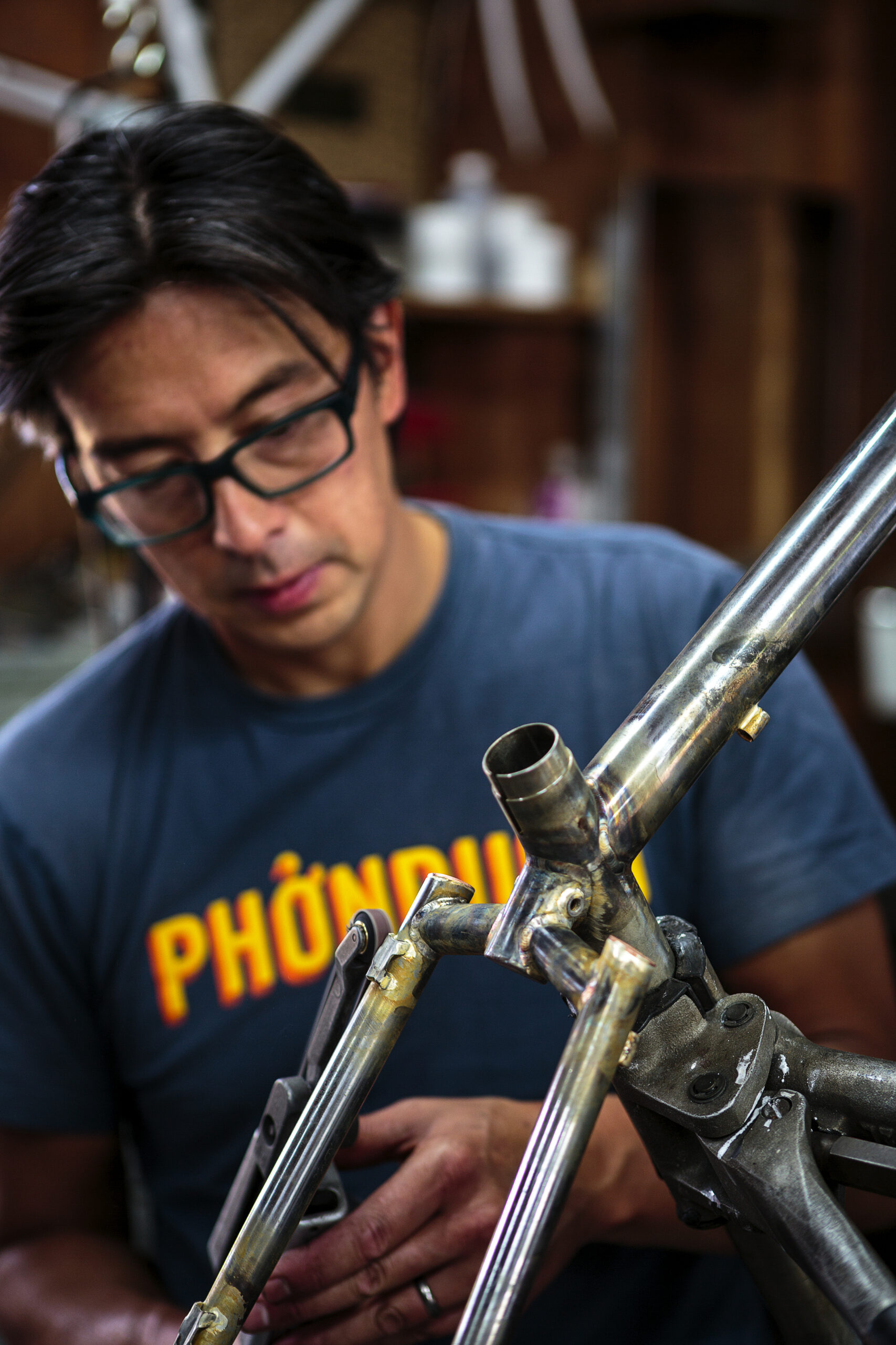 Jeremy Sycip, builder of custom bikes with some of his bikes and an exploded view of a bike