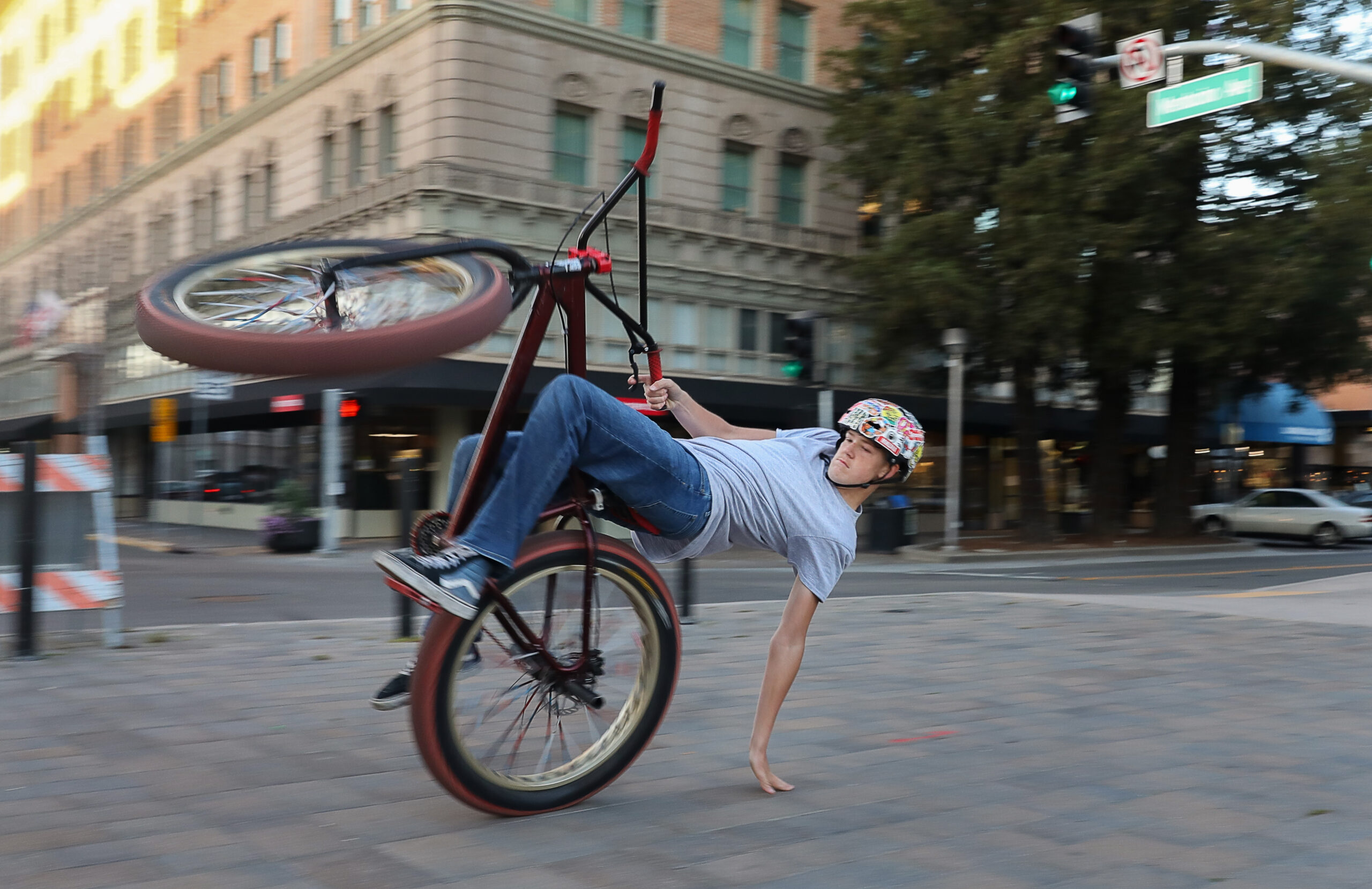Devan Tucker leans back to touch the ground while performing a wheelie on his bike at Old Courthouse Square in Santa Rosa on Thursday, March 4, 2021. (Christopher Chung/ The Press Democrat)