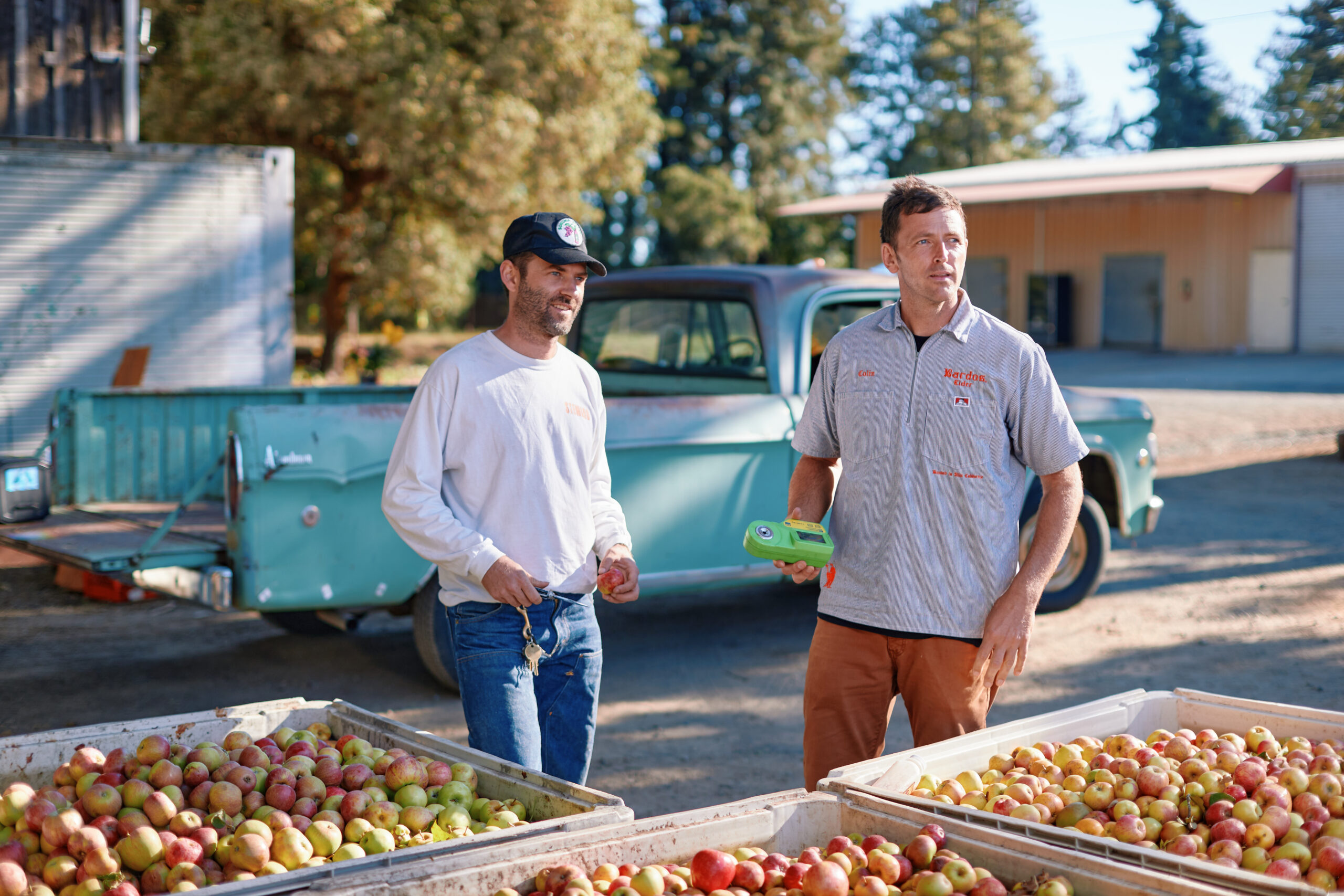 Aaron Brown, in white shirt, and Colin Blackshear at Ratzlaff Ranch, where they press their fruit. (Photo by Kim Carroll)