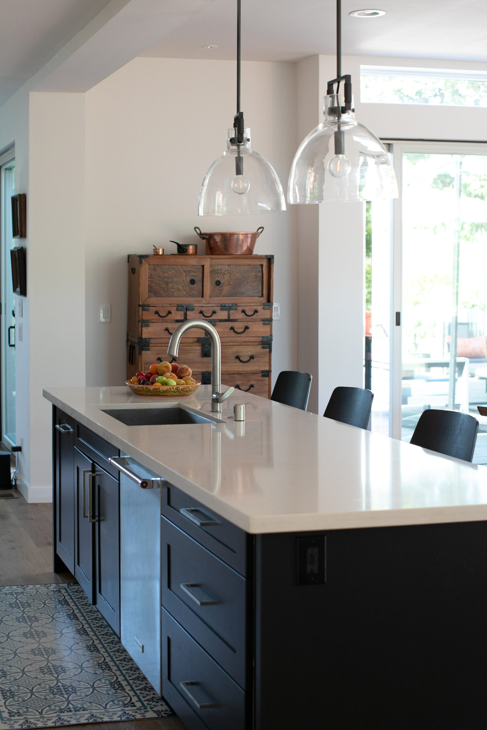 Lauri Dorman, a passionate home cook, enjoys the new kitchen. The Japanese tansu chest, above left, replaces an antique lost in the fire, which the family had purchased while living in Japan for Tim’s job. (Eileen Roche)