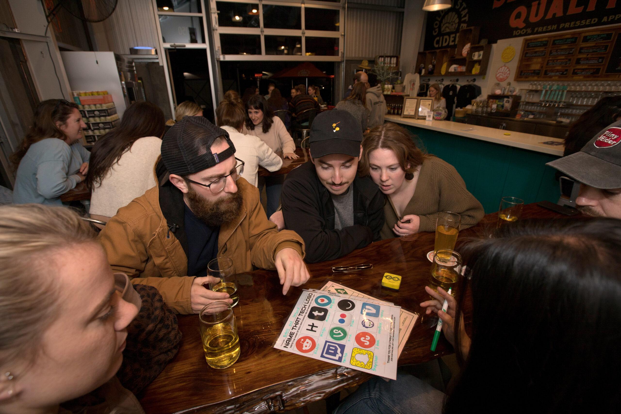 Left to right (center), Tanner Faber, Michael Estens, and Katie-Lauren Dunbar, all of Santa Rosa, who call themselves the "Bidets and Confused," discuss their answers to questions during trivia night presented by North Bay Trivia at Golden State Cider Taproom, Thursday, Oct. 13, 2022, in Sebastopol. 