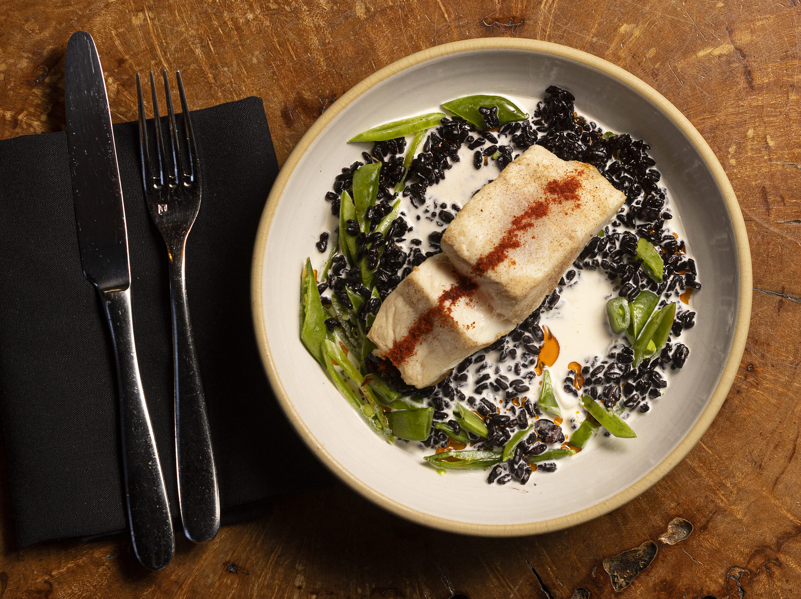 Corvina in a coconut citrus broth with snap peas, and Espelette oil from the Coast Kitchen at the Timber Cove Resort on the Sonoma Coast. (John Burgess/The Press Democrat)