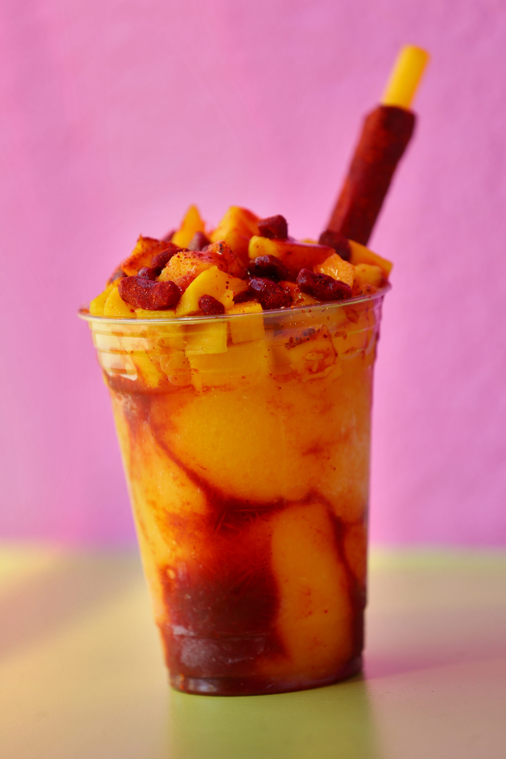 A Mangonada made by Teresita Fernandez at La Michoacana in Sonoma. The drink consists of blended fresh mango with ice, swirled chamoy sauce, topped with mango chunks and tamarind candy, and a tamarind stick. (Christopher Chung/ The Press Democrat)