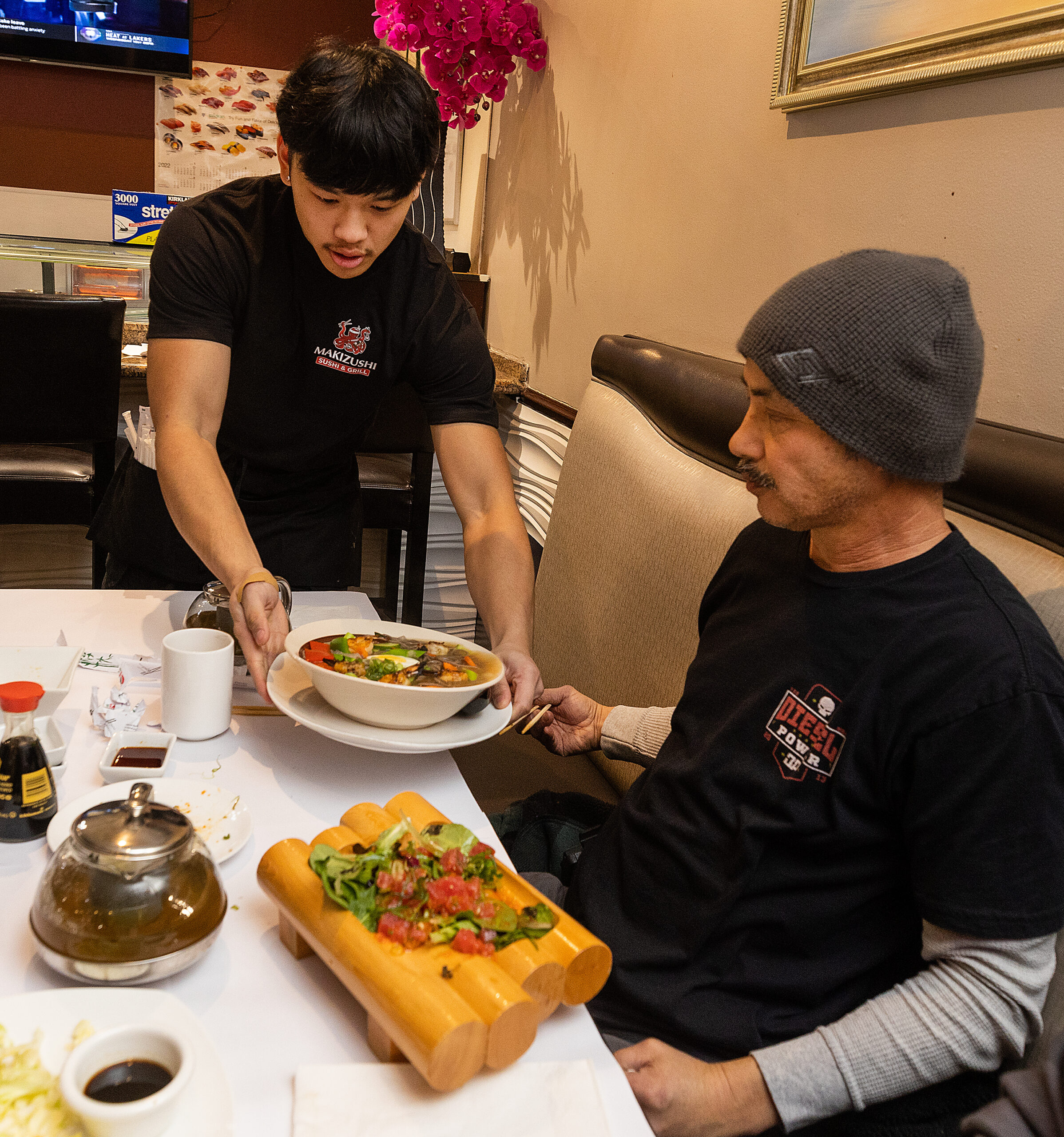 Robert Phouthavong, 18, owner of Makizushi delivers an order to Tom Hong at the Santa Rosa restaurant Tuesday, January 3, 2023. Robert and his father Southavichit opened the restaurant after learning the business at Hana Sushi in Sebastopol. (John Burgess/The Press Democrat)