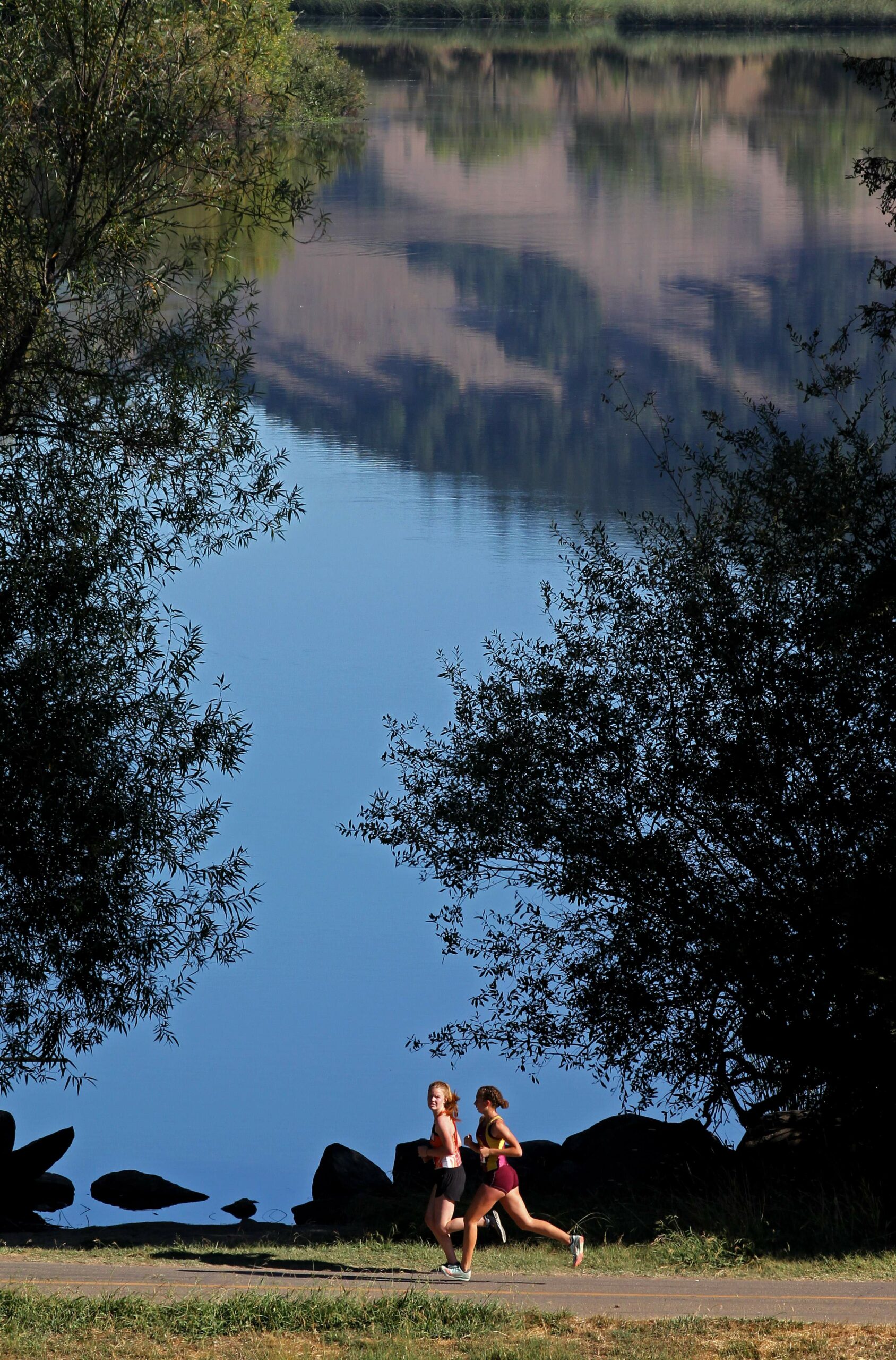 Freshman-Sophomore Girls run with Spring Lake in the background, at Montgomery High School's Viking Opener Invitational held at Spring Lake Regional Park in Santa Rosa, on Saturday, September 14, 2019. (Photo by Darryl Bush / For The Press Democrat)