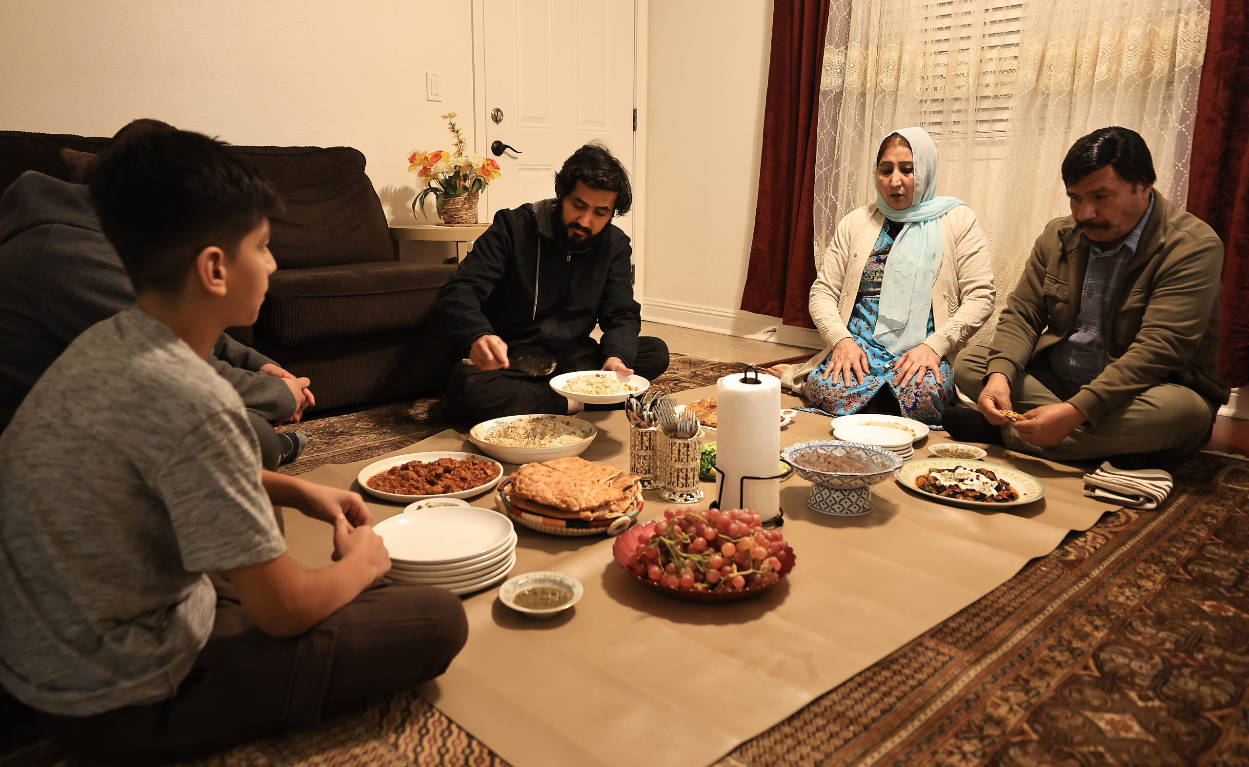 Roman Zimari, middle, joins his family for a traditional evening meal, Wednesday, Nov. 16, 2022 at their apartment in Santa Rosa. (Kent Porter / The Press Democrat) 2022