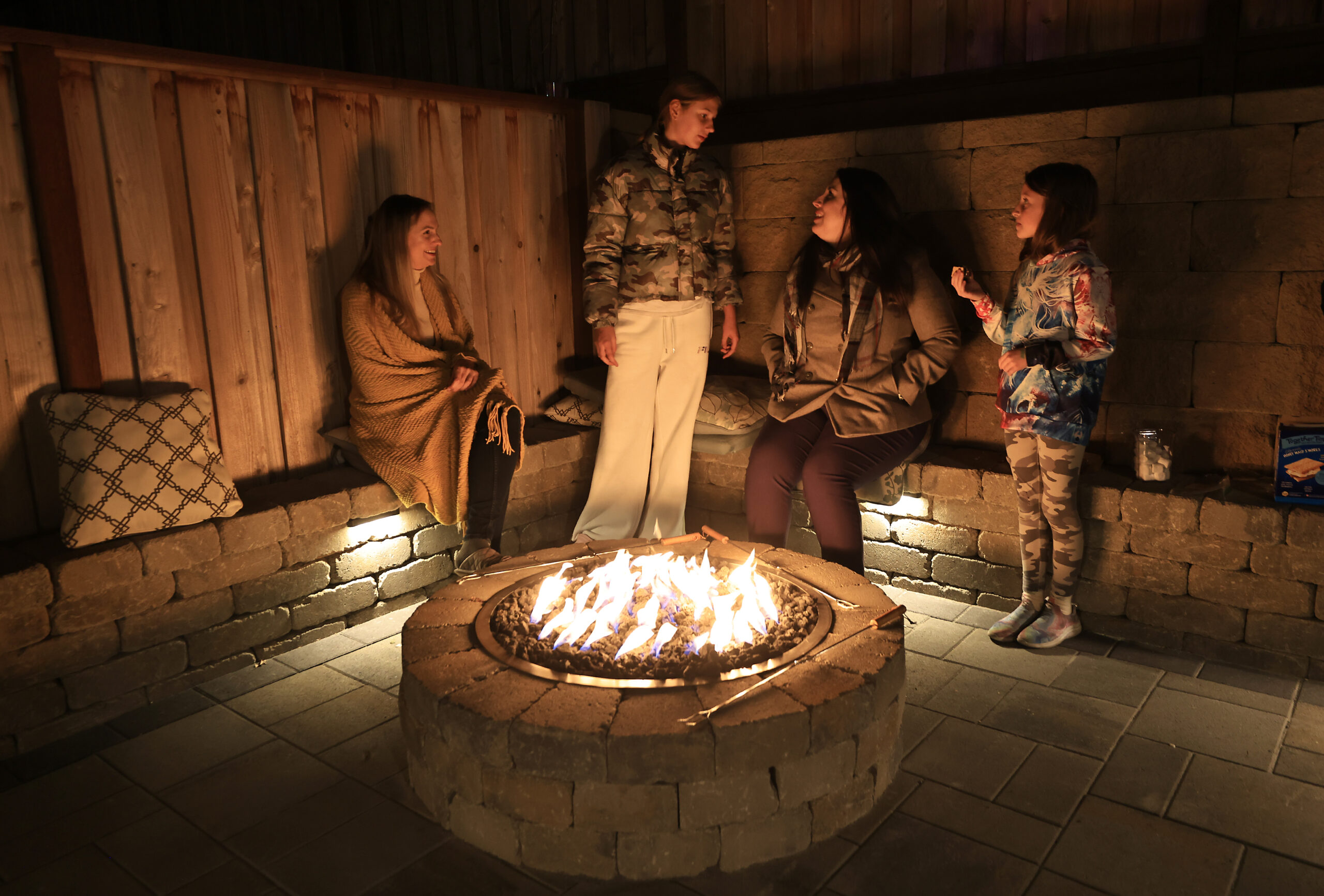 At left, Ukrainians Anna Tereshenko and daughter Yeva Perepechaieva, 12, roast marshmallows with sponsor family Marry-Catherine Oxford and her daughter Emerald, 8, Thursday, Nov. 17, 2022 in Santa Rosa. Tereshenko and Perepechaieva fled the Dnipro region of eastern Ukraine. (Kent Porter / The Press Democrat) 2022