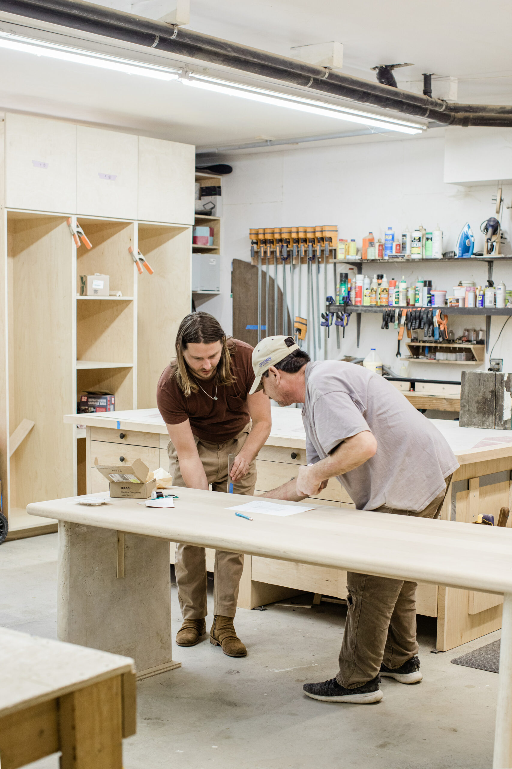 Alex Mutter-Rottmayer, left, reviews a custom furniture design in the workshop. (Eileen Roche/For Sonoma Magazine)
