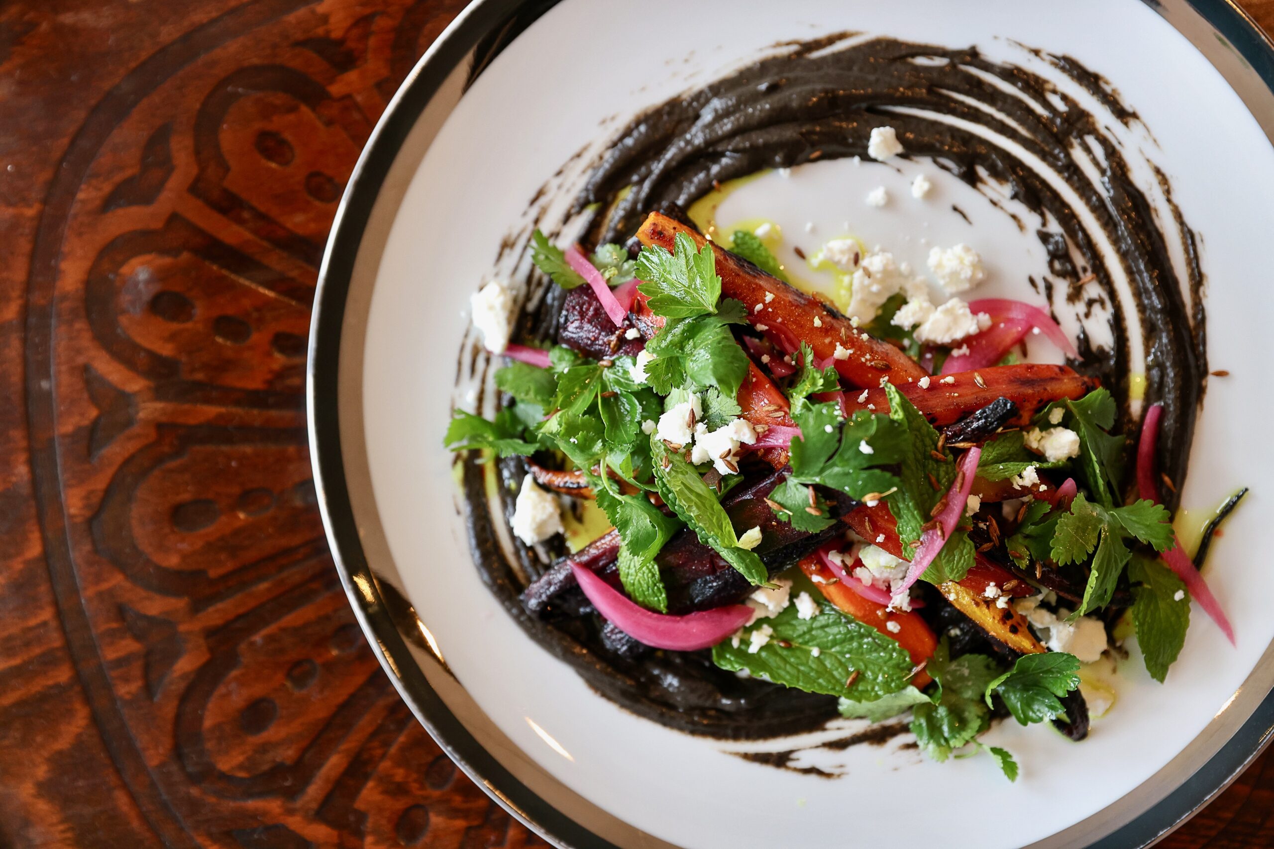 Grilled Carrots with Black Sauce, made with herbs, feta, local honey and fried cumin at The Redwood in Sebastopol. (Christopher Chung / The Press Democrat)