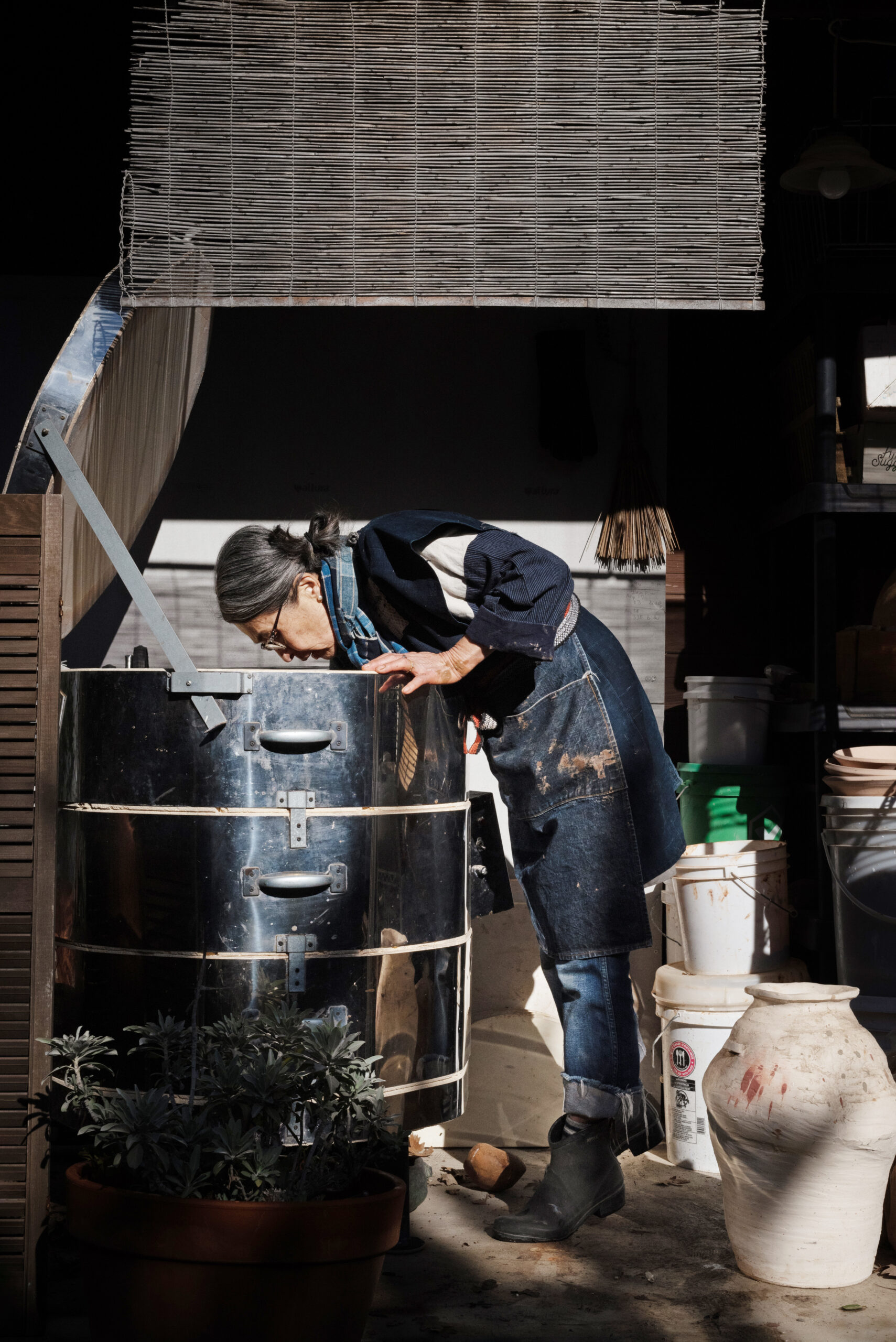 The artist reaches deep into her kiln to check on a batch of pieces ready to be fired. (Erik Castro/for Sonoma Magazine)