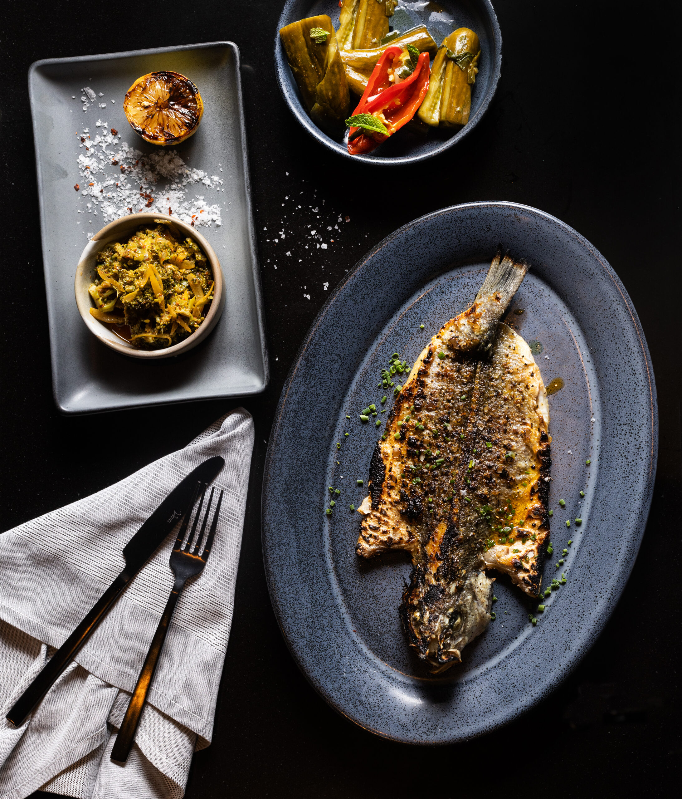 Whole Grilled Bronzino with a side of Broccoli Tabbouleh and homemade pickles from Goldfinch restaurant Wednesday, May 24, 2023, in Sebastopol. (John Burgess/The Press Democrat)