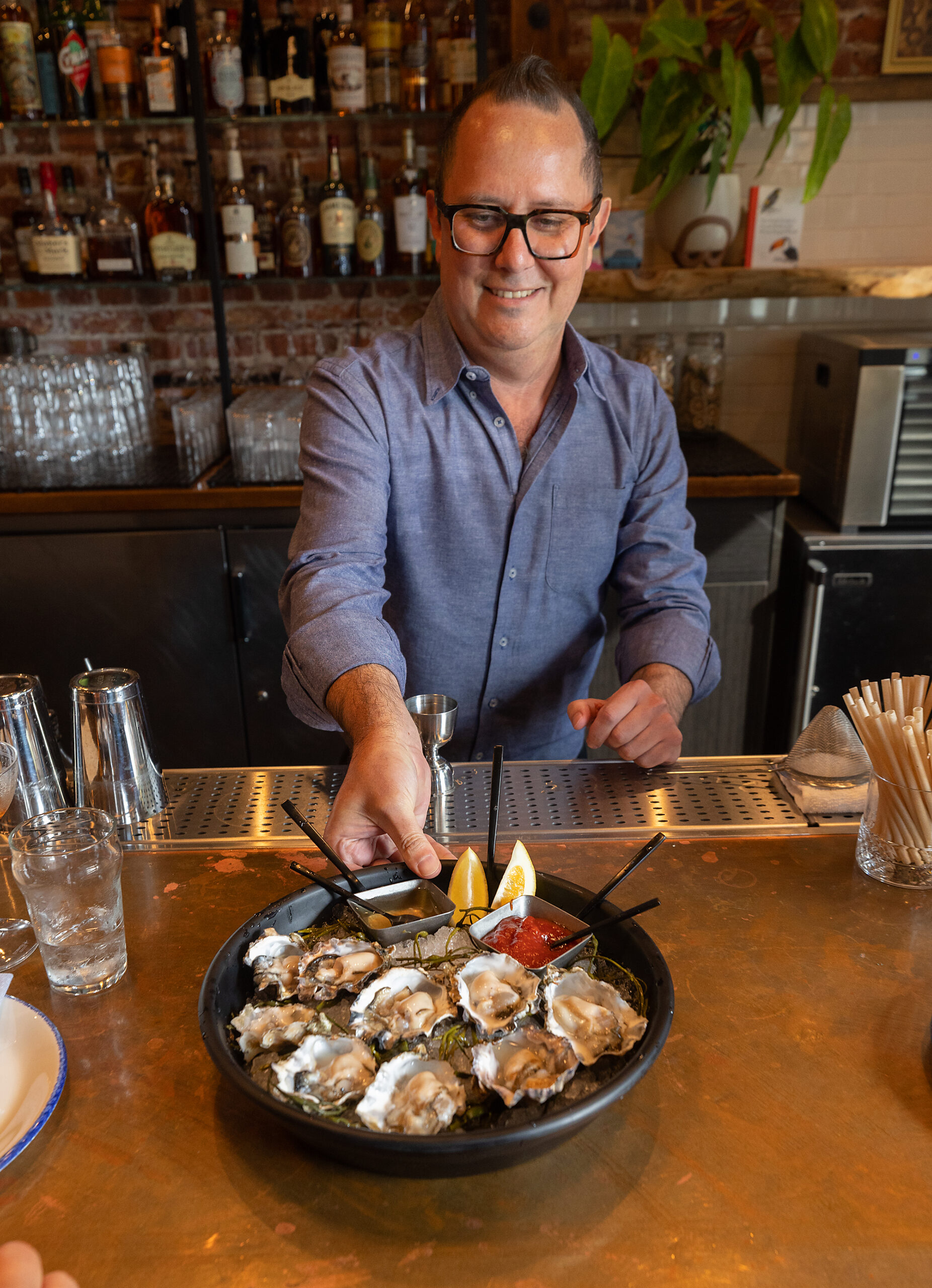 Co-owner Nick Izzarelli serves up a plate of oysters to patrons at the Goldfinch bar Wednesday, May 24, 2023, in Sebastopol. (John Burgess/The Press Democrat)