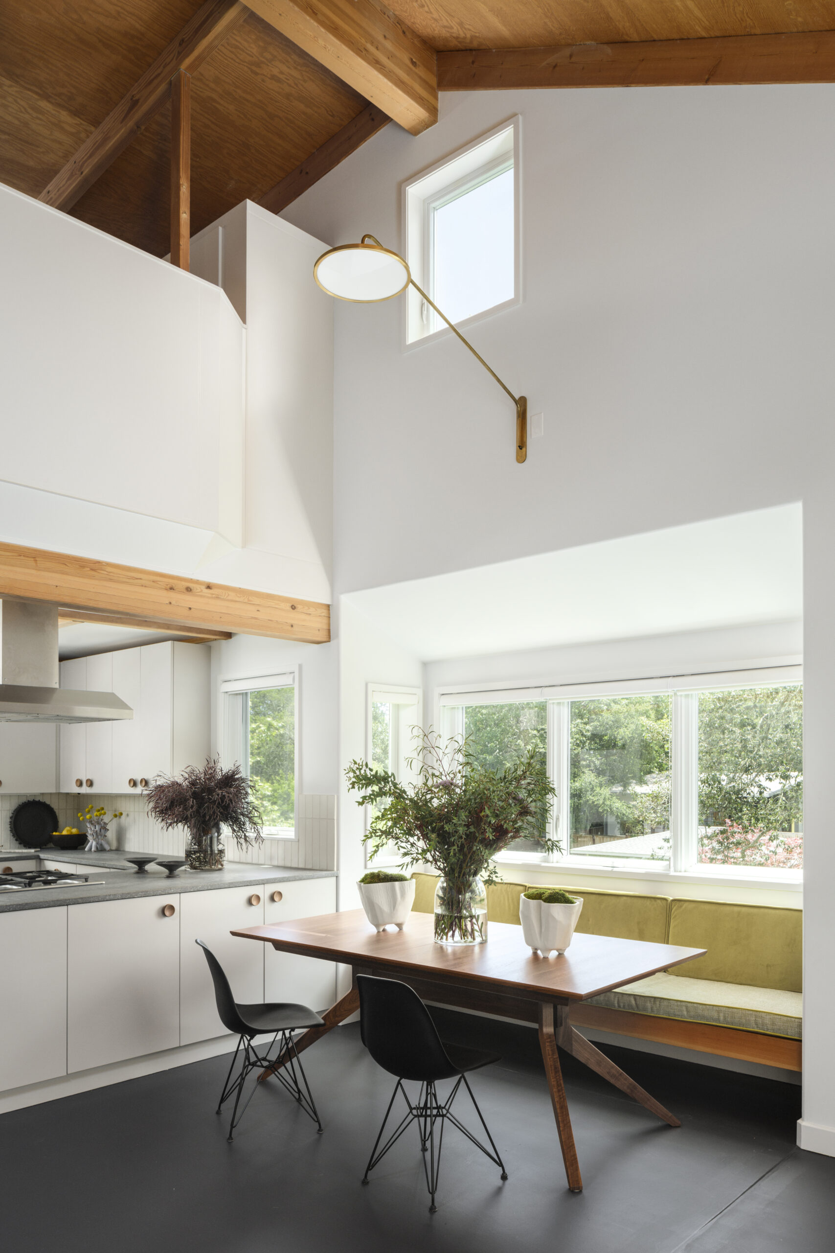 Small design details make the project sing, like oversized walnut knobs in the kitchen, leather welting on the velvet upholstery in the dining nook, and brass sconces wired high up to give plenty of light. (Christopher Stark)