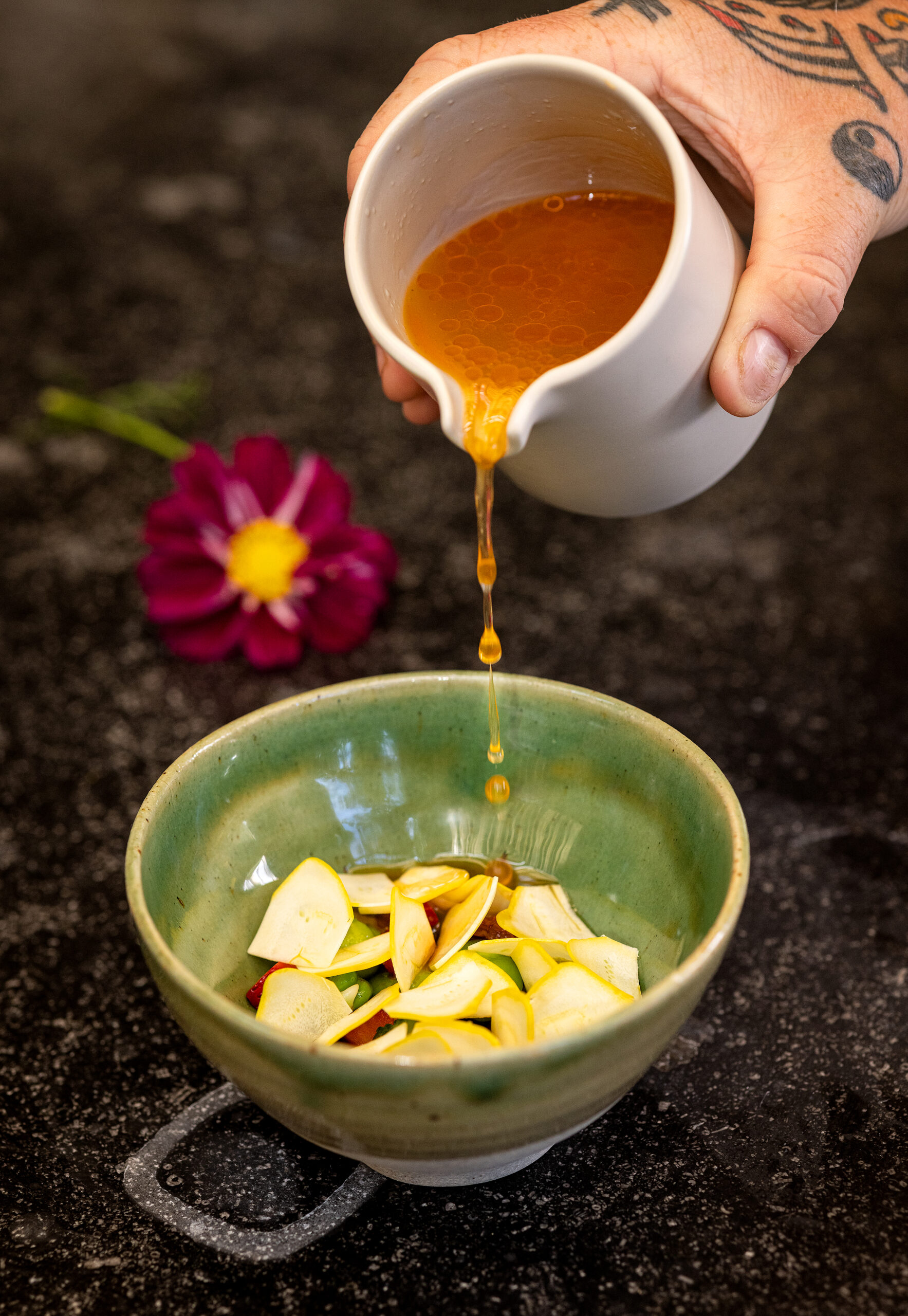 A pour of miso at the table over Summer Vegetables with Smoked Tomatoes from the vegan prix fixe menu from chef Stu Stalker on weekends at Second Story, the new upstairs restaurant at Little Saint in Healdsburg September 8, 2023. (Photo John Burgess/The Press Democrat)