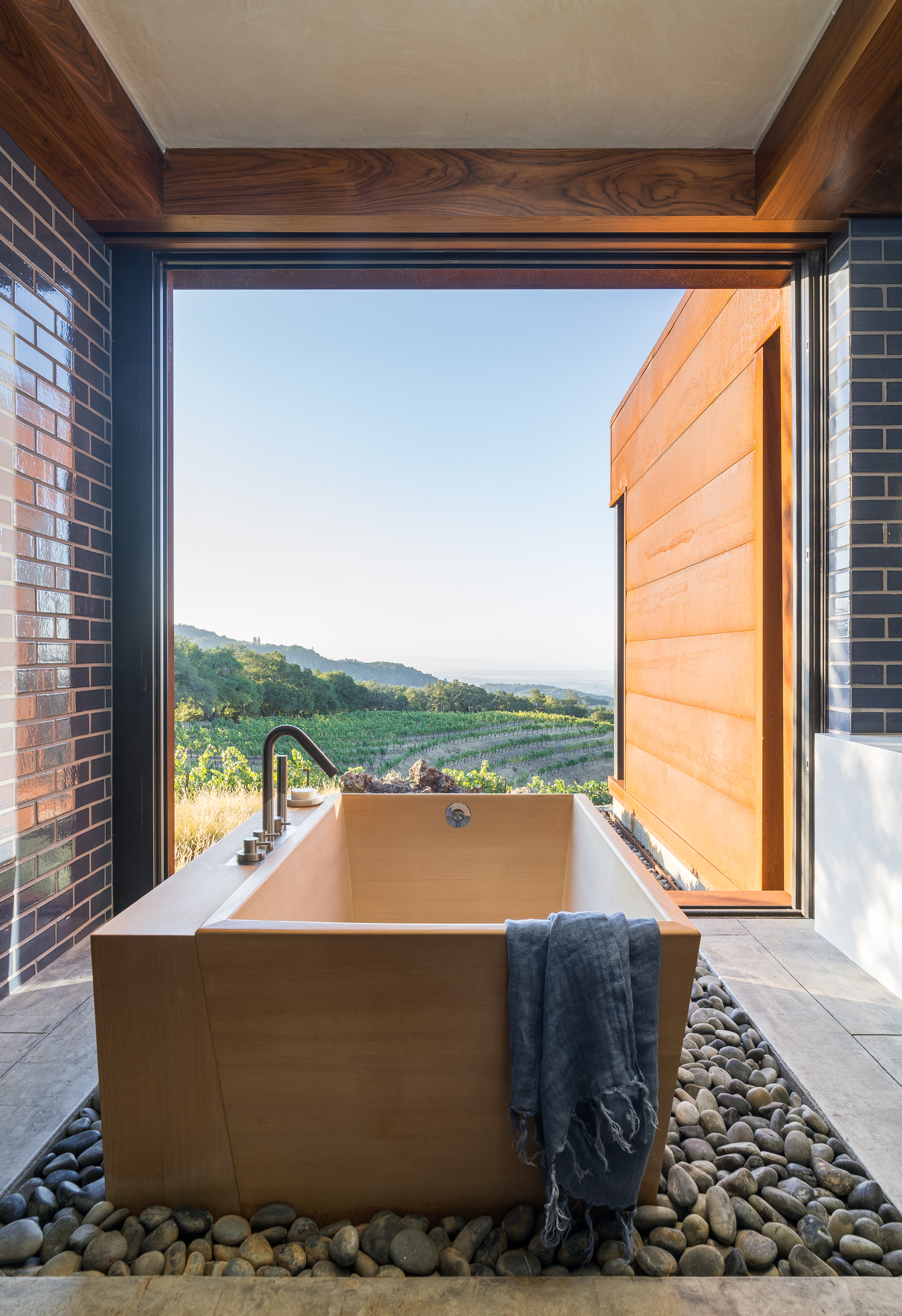 A deep soaking tub on a bed of smooth river stones brings a sense of calm to the primary bath.