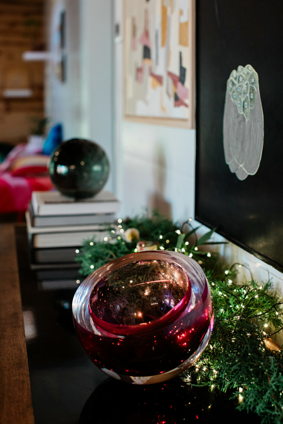 Karen creates simple holiday displays of foraged greens, lights, and SkLO glass in jewel colors. (Eileen Roche/For Sonoma Magazine)