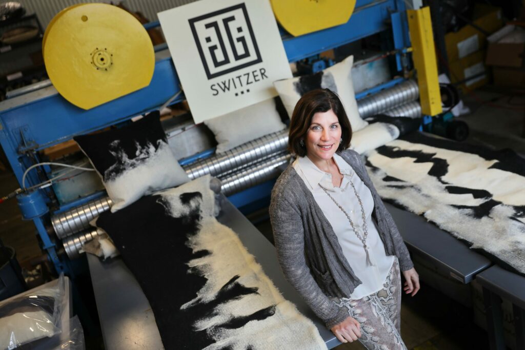 Jessica Switzer Green, founder of JG Switzer, with some of her company's Heritage Sheep Collection, in the Genesis fabric style, and needle loom. JG Swtizer produces luxury blankets and bedding out of a workshop at The Barlow, in Sebastopol. (Christopher Chung/ The Press Democrat)