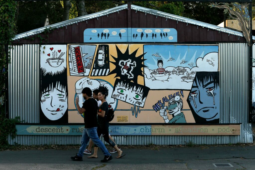 Pedestrians walk past a mural created by Daniel Doughty and Nick Jensen at Art Alley in the SOFA arts district in Santa Rosa. (Alvin Jornada/The Press Democrat)