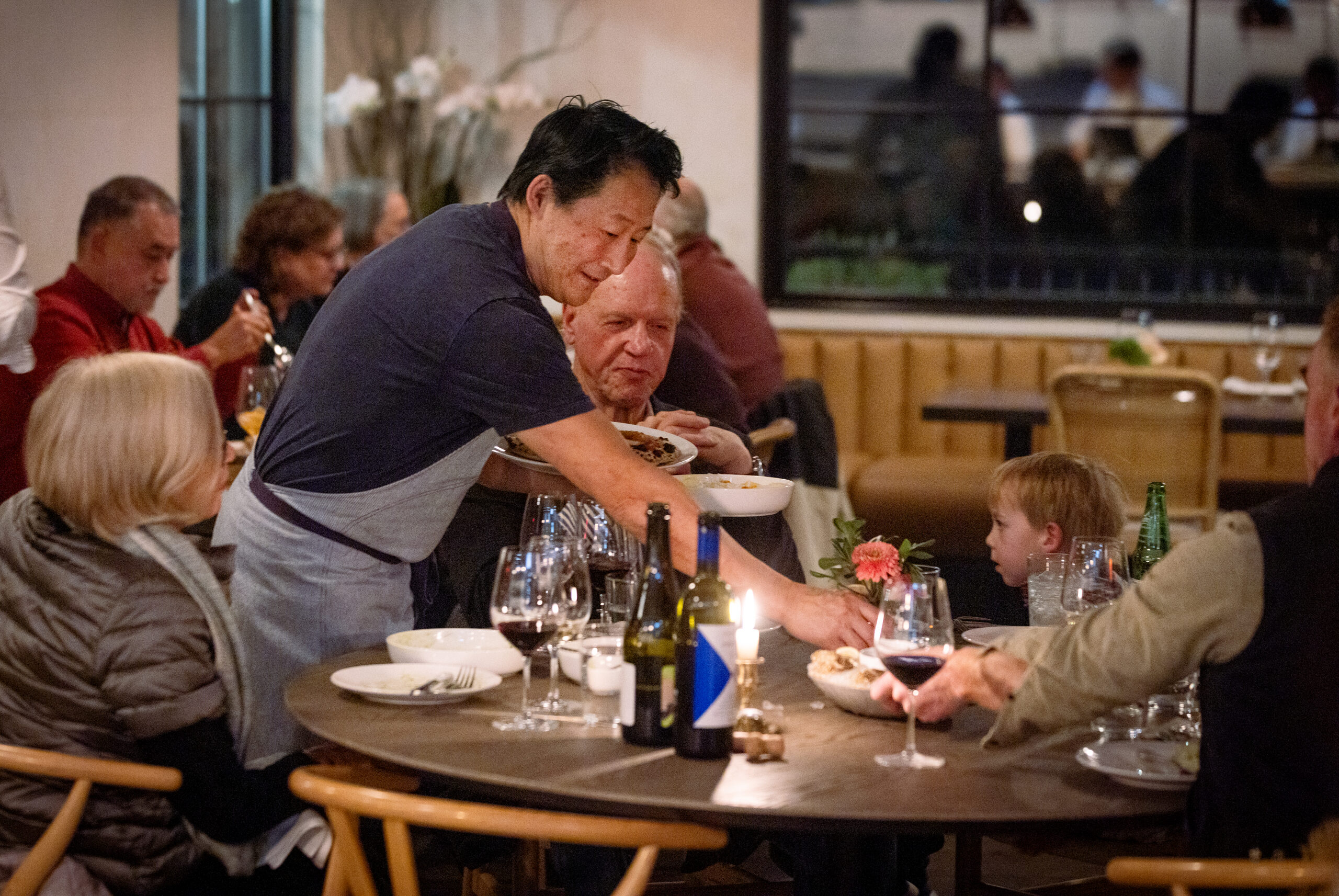 Owner Joshua Smookler delivers plates to a family table at the Golden Bear Station Thursday, January 11, 2023, on Highway 12 in Kenwood. (John Burgess/The Press Democrat)