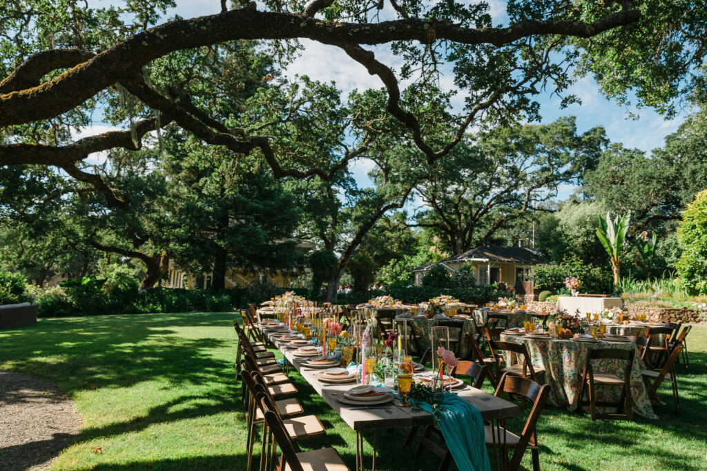 The tables are set under the oak trees at Beltane Ranch. 