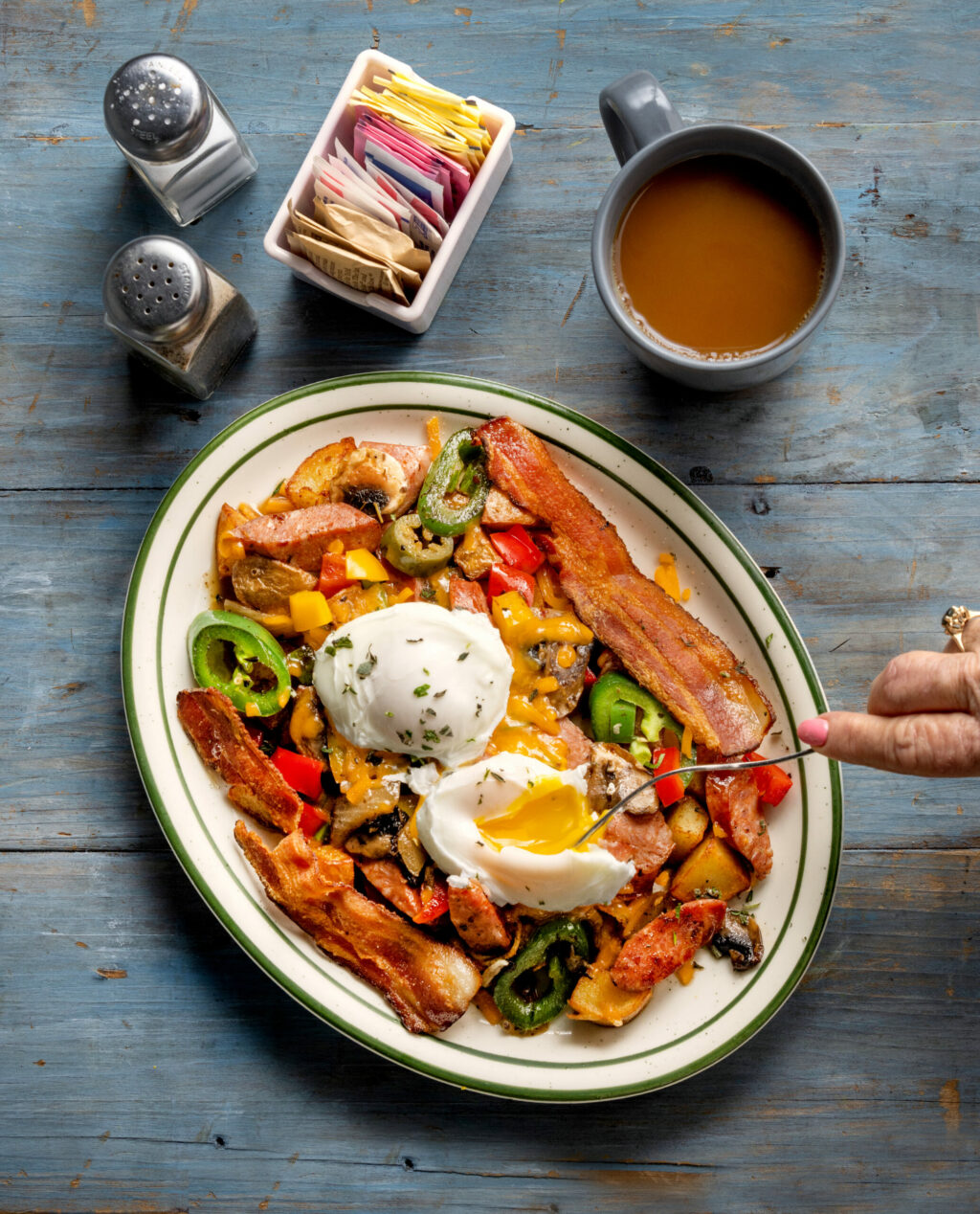 Louisiana Hash with onions, bell peppers, bacon, potatoes, cheddar, eggs, herbs, mushrooms and spicy seasoning from J & M’s Midtown Cafe, Thursday, Jan. 18, 2024, in Santa Rosa. (John Burgess / The Press Democrat)