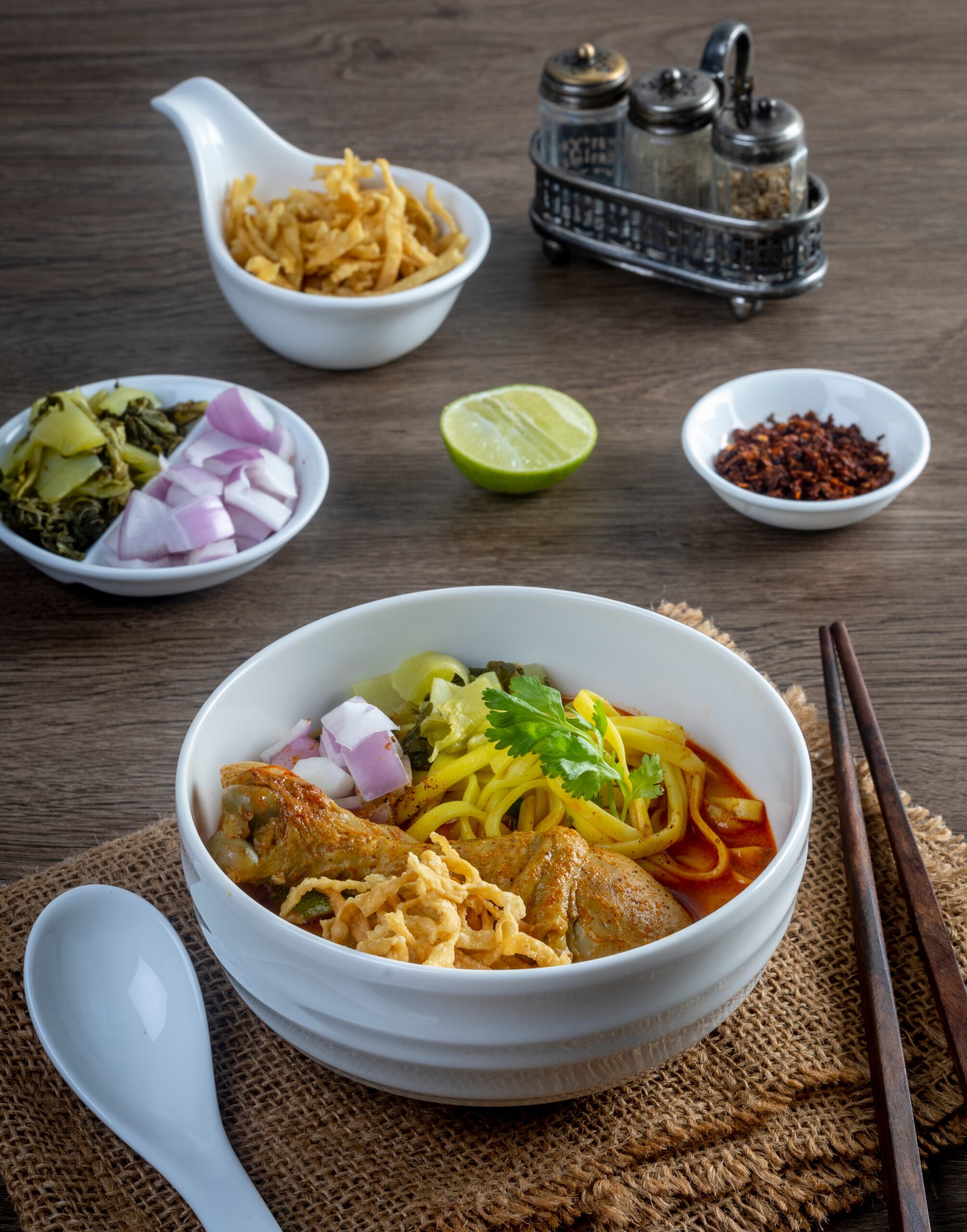 Khao Soi with sides of spices and garnishes