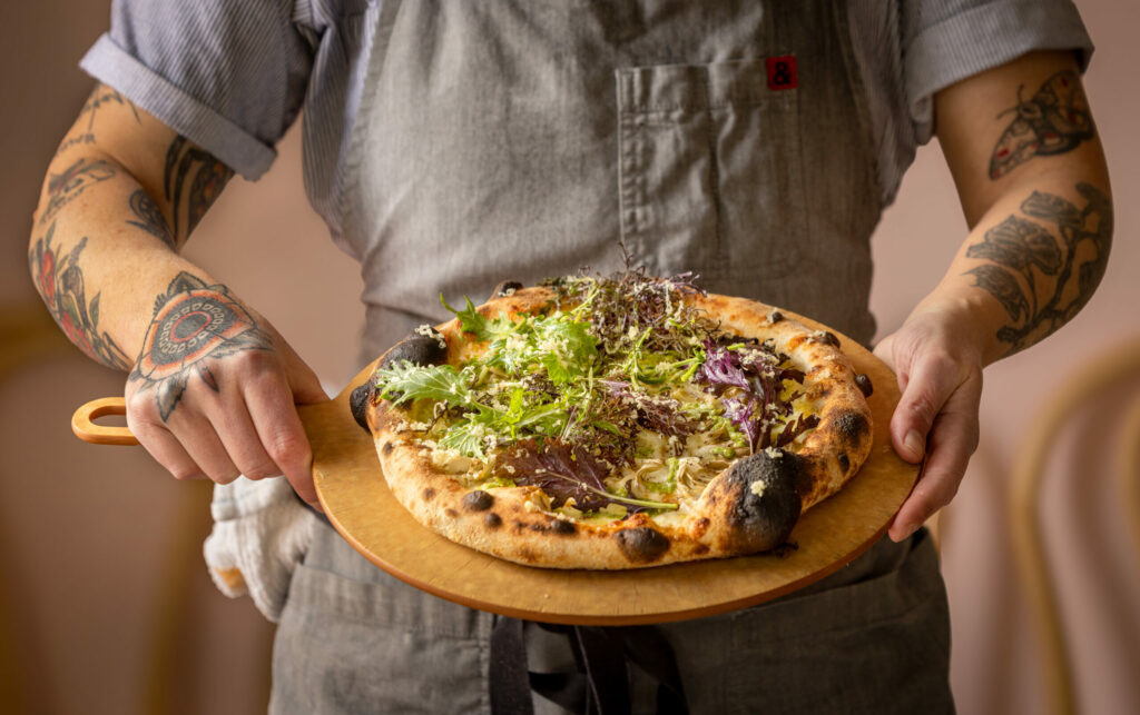 The Pretty Fly for a Fungi with pesto, white sauce, mushrooms, Valley Ford Estero Gold Reserve cheese topped with arugula rom Slow Co. Pizza Friday, Dec. 20, 2024, in Cotati. (John Burgess / The Press Democrat)
