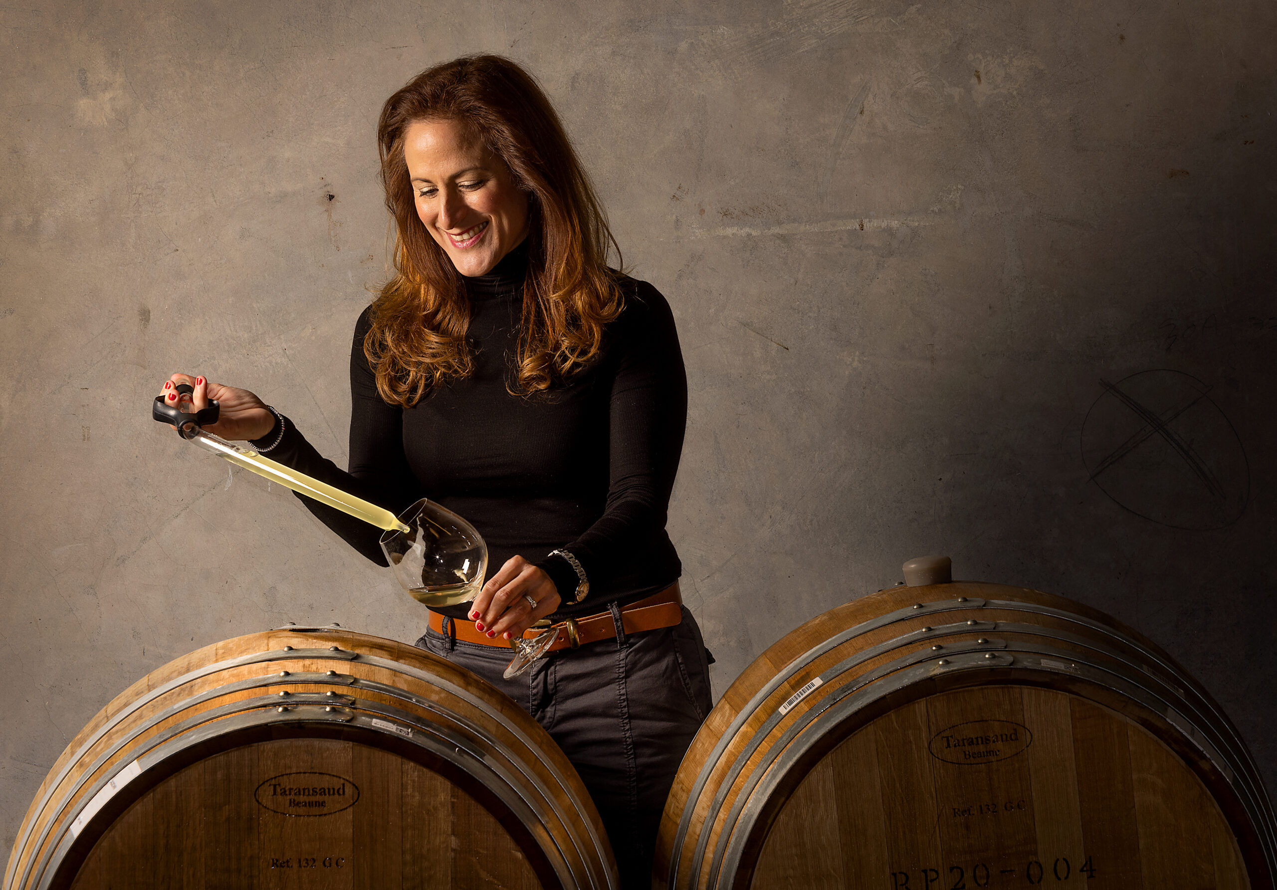 Winemaker Bibiana Gonzalez Rave tests wine from a barrel
