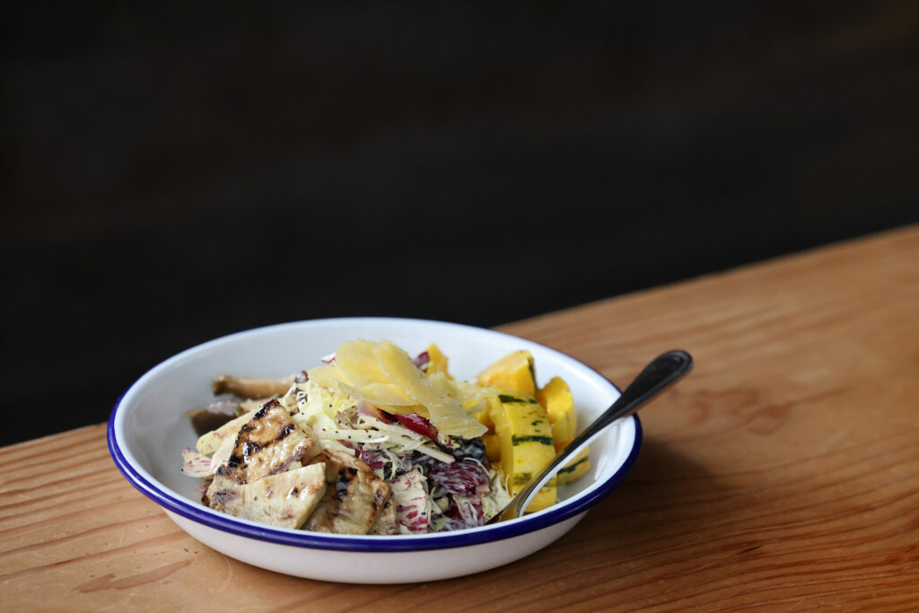 A “Roots and Shoots” bowl with sprouted lentils, roasted delicata squash, grilled celery root, trumpet mushroom conserva, chicory and apple salad, with a pomegranate, pumpkin seed tahini, and topped with Estero Gold Cheese. Photo taken at Handline in Sebastopol Wednesday, Feb. 12, 2025. (Beth Schlanker / The Press Democrat)