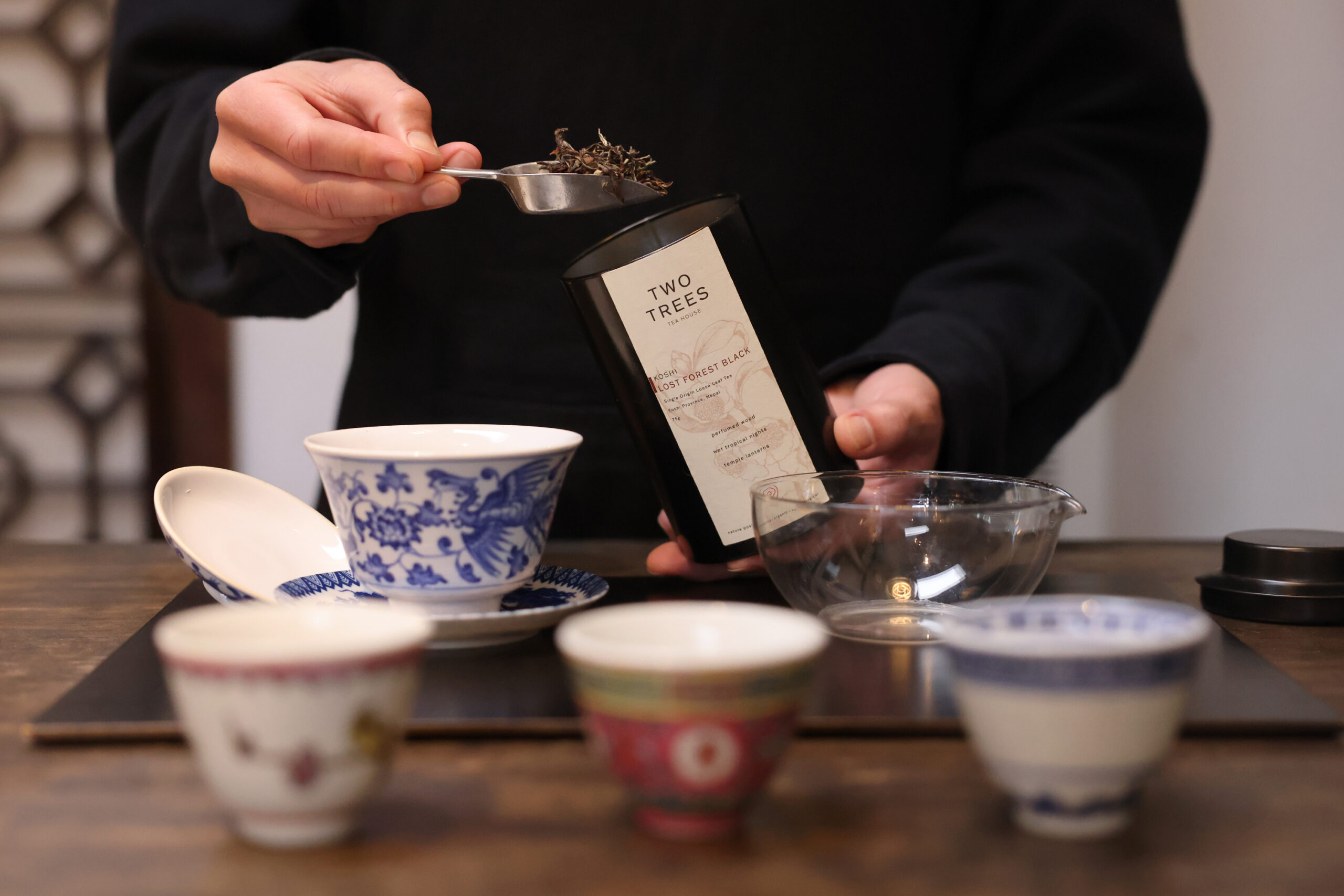 Owner Adrian Chang scoops Lost Forest Black tea leaves into a cup to steep with water at Two Trees Tea House in Occidental Wednesday, Feb. 12, 2025. (Beth Schlanker / The Press Democrat)