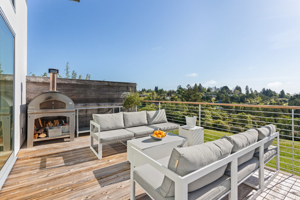 Cooking and seating area on the deck of a foodie lover's dream home