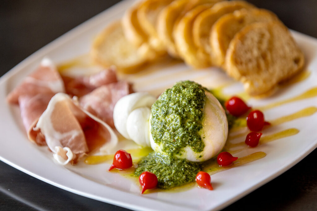 Grata Burrata with preserved lemon honey, pesto, pickled sweetdrop peppers with crostini and prosciutto from Grata Italian Eatery chef/owner Eric Foster Thursday, May 8, 2025, in Windsor. (John Burgess / The Press Democrat)