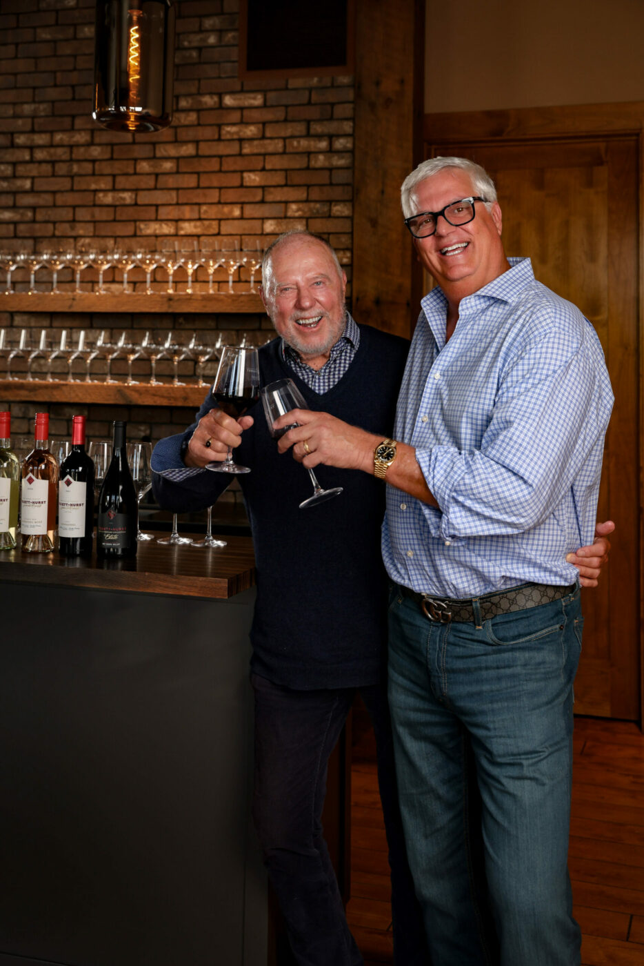 Phil Hurst, right, and Ken Wilson pose with Truett Hurst wine in the tasting room set to open at 113 Mill St. in Healdsburg in early April 2024. (Will Bucquoy Photography) March 21, 2024